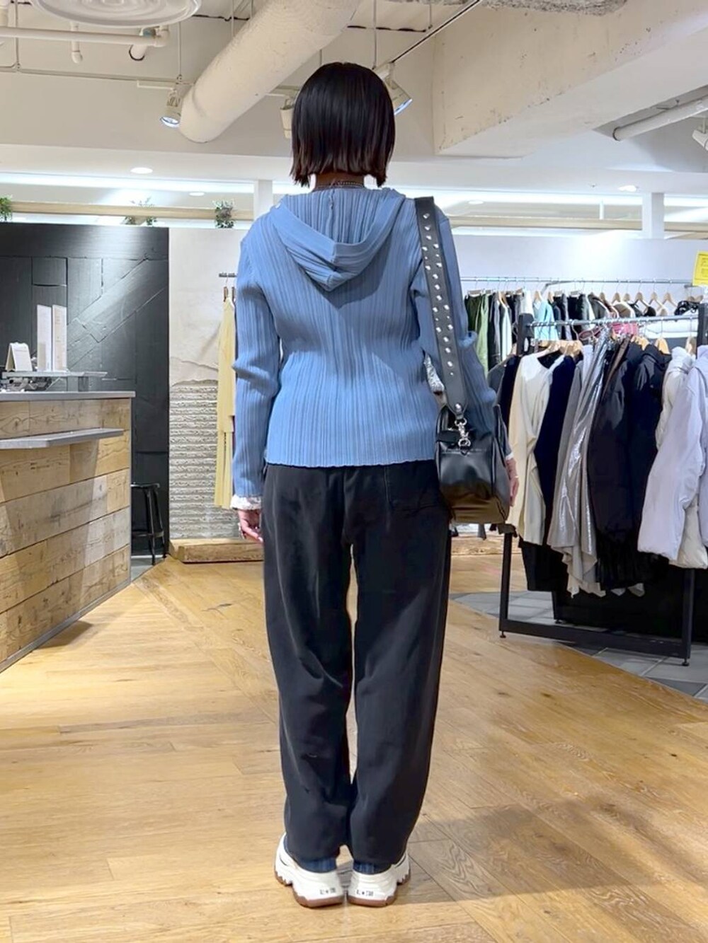 ブラック系のスウェットパンツ、ブルー系のスニーカー、ブラック系のボストンバッグを着用したレディースの冬コーディネートの4枚目の写真