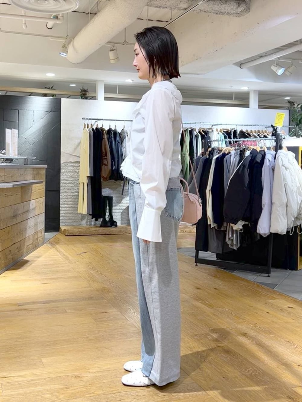 ピンク系のボストンバッグ、ブルー系のデニムパンツ、ホワイト系のドレスシューズを着用したレディースの冬コーディネートの4枚目の写真