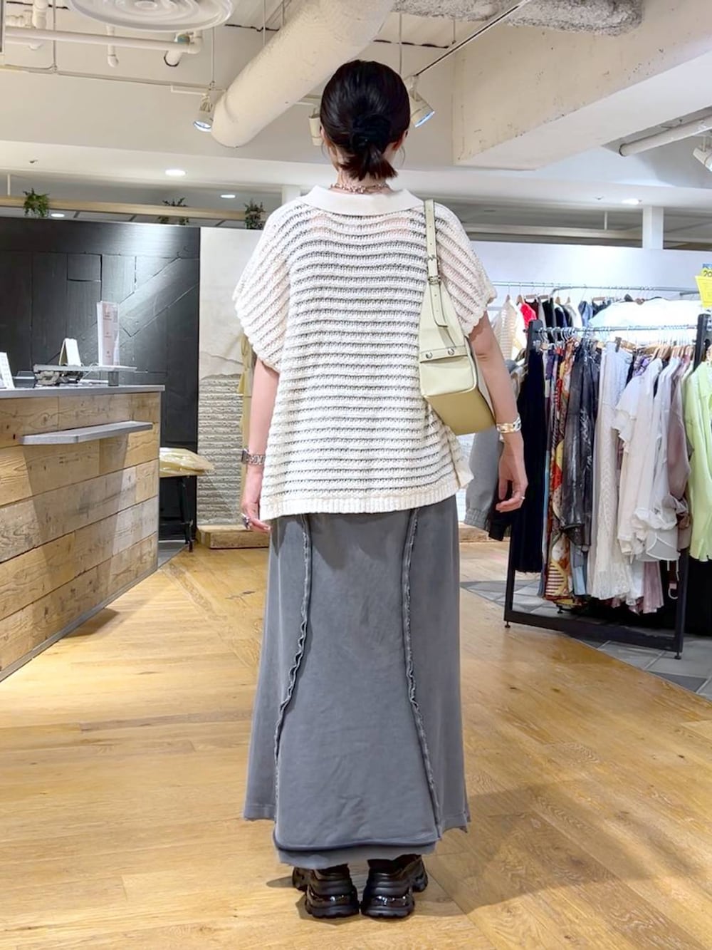 ブラック系のタンクトップ、グレー系のスカート、ブラック系のサンダルを着用したレディースの春コーディネートの6枚目の写真