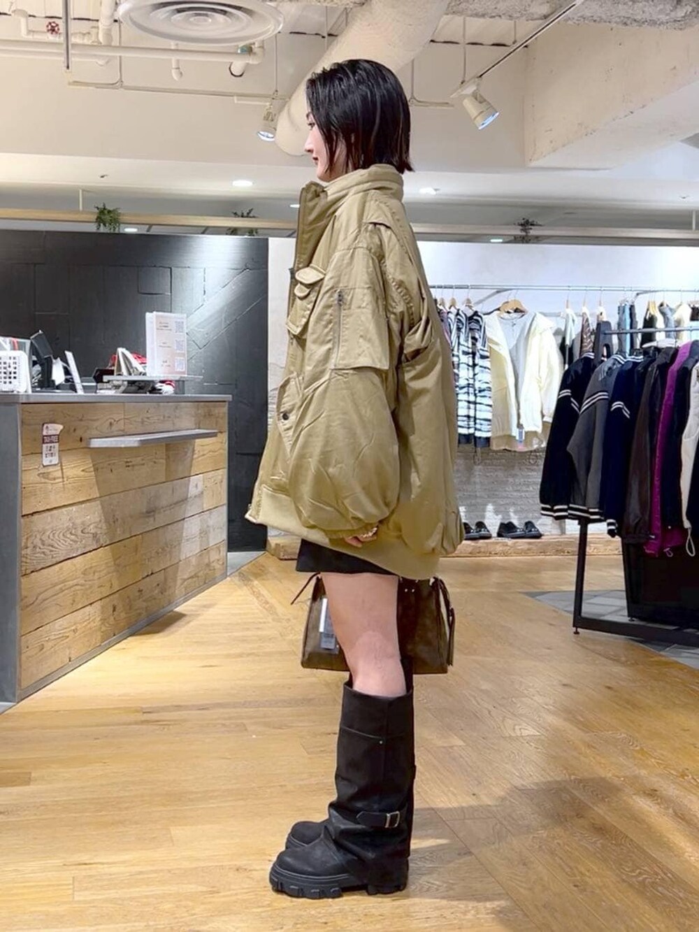 ブラウン系のボストンバッグ、ブラック系のブーツ、ブラック系のその他パンツを着用したレディースの冬コーディネートの5枚目の写真