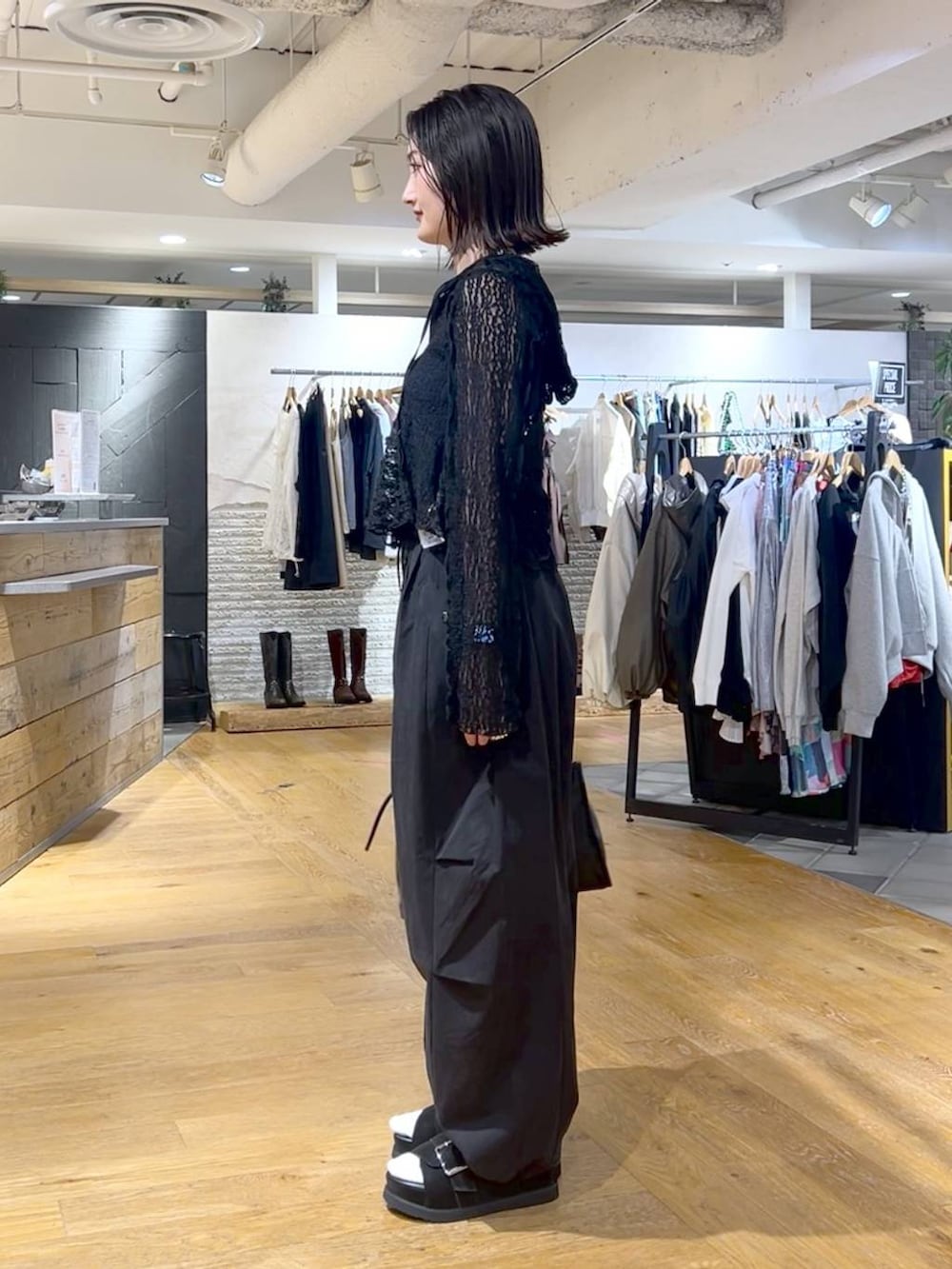 ブラック系のボストンバッグ、ブルー系のタンクトップ、ブラック系のその他パンツを着用したレディースの春コーディネートの3枚目の写真