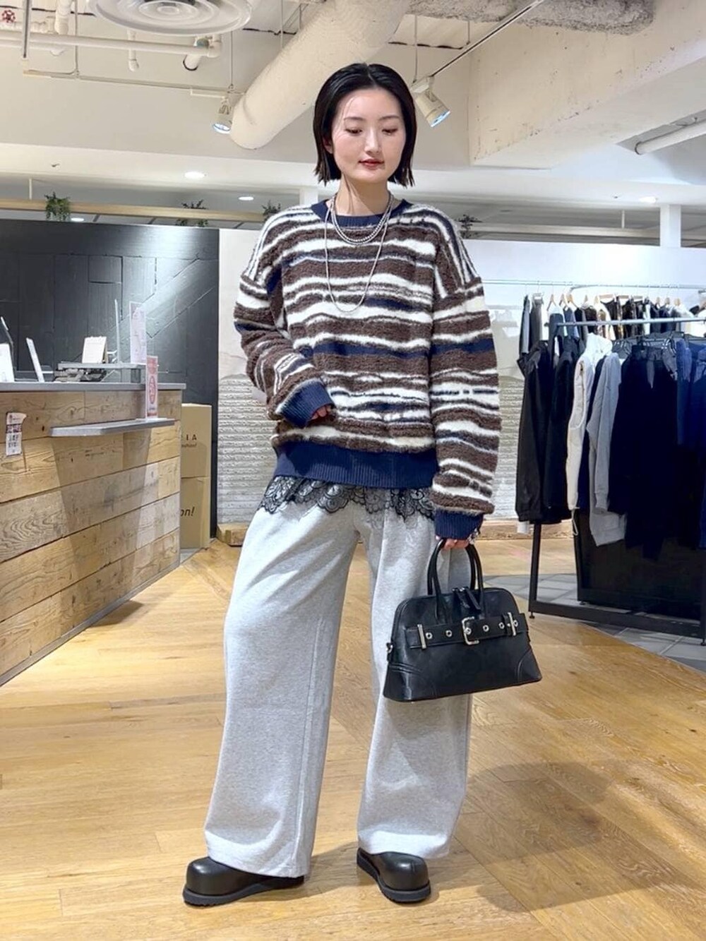 ブラック系のその他シューズ、ブラック系のボストンバッグ、ブラック系のTシャツ/カットソーを着用したレディースの冬コーディネートの2枚目の写真