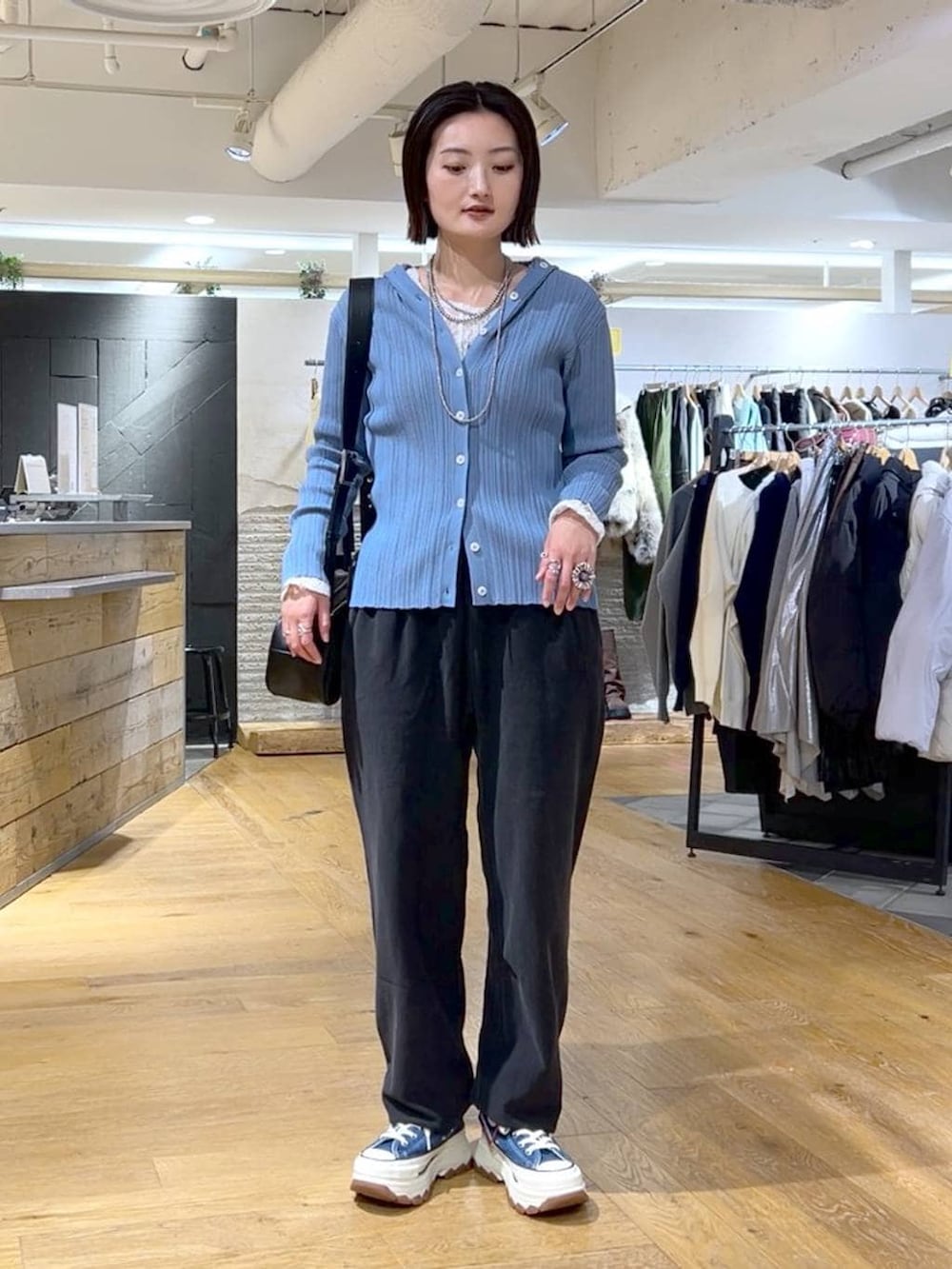 ブラック系のスウェットパンツ、ブルー系のスニーカー、ブラック系のボストンバッグを着用したレディースの冬コーディネートの2枚目の写真