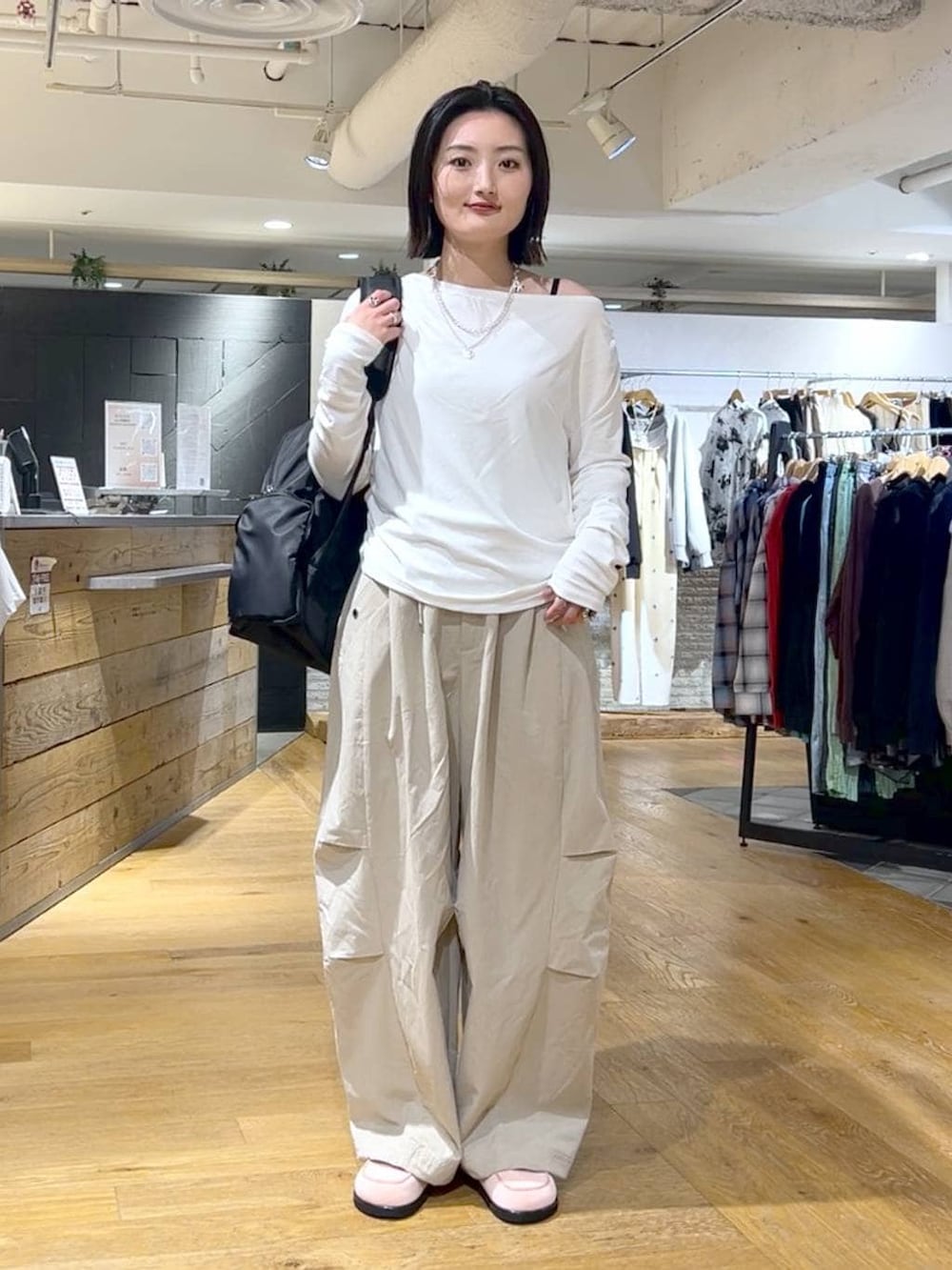 ホワイト系のTシャツ/カットソー、ブラック系のバックパック/リュック、ピンク系のローファーを着用したレディースの春コーディネートの2枚目の写真