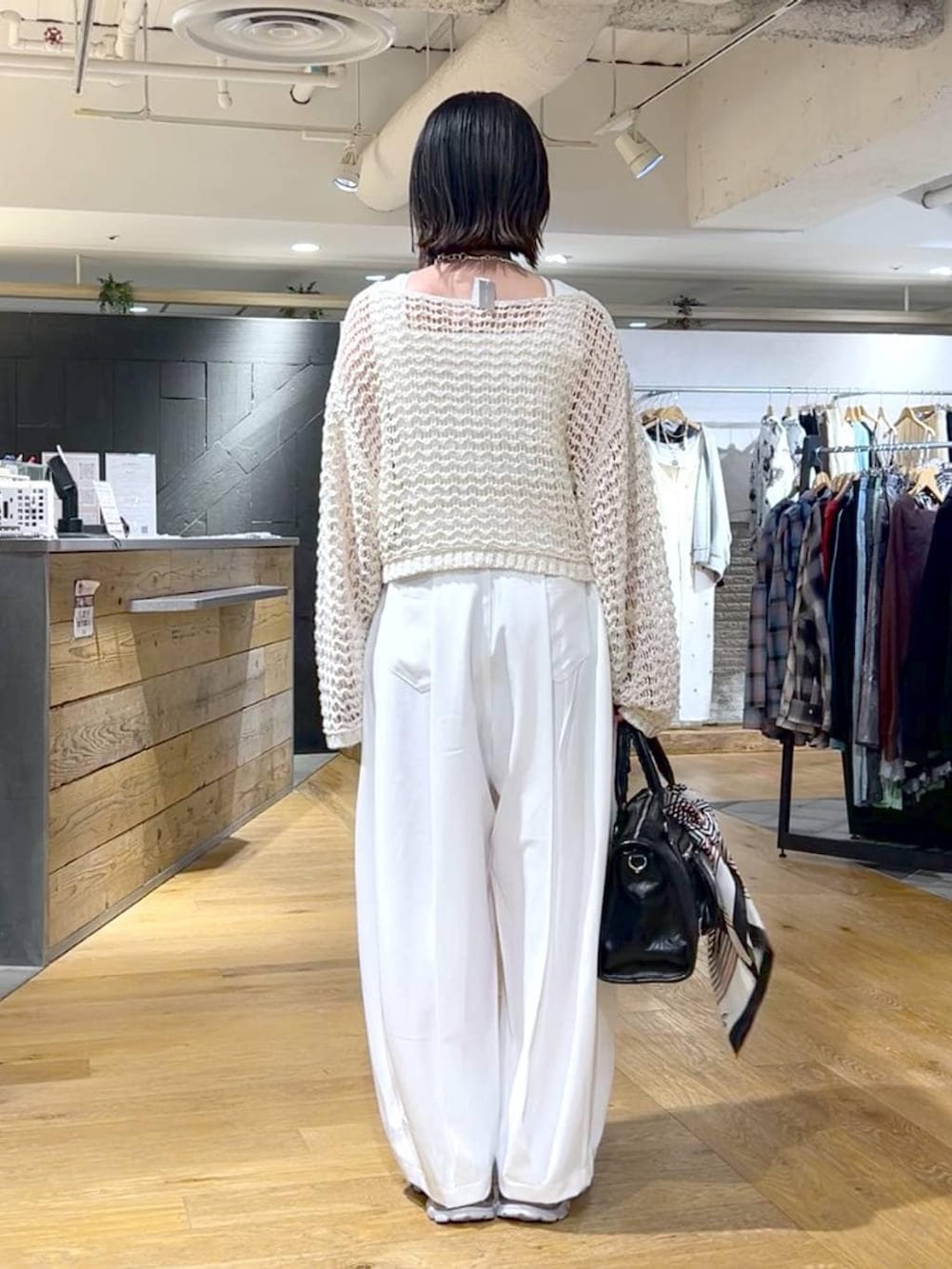 シルバー系のローファー、ブラック系のボストンバッグ、ホワイト系のニット/セーターを着用したレディースの春コーディネートの5枚目の写真