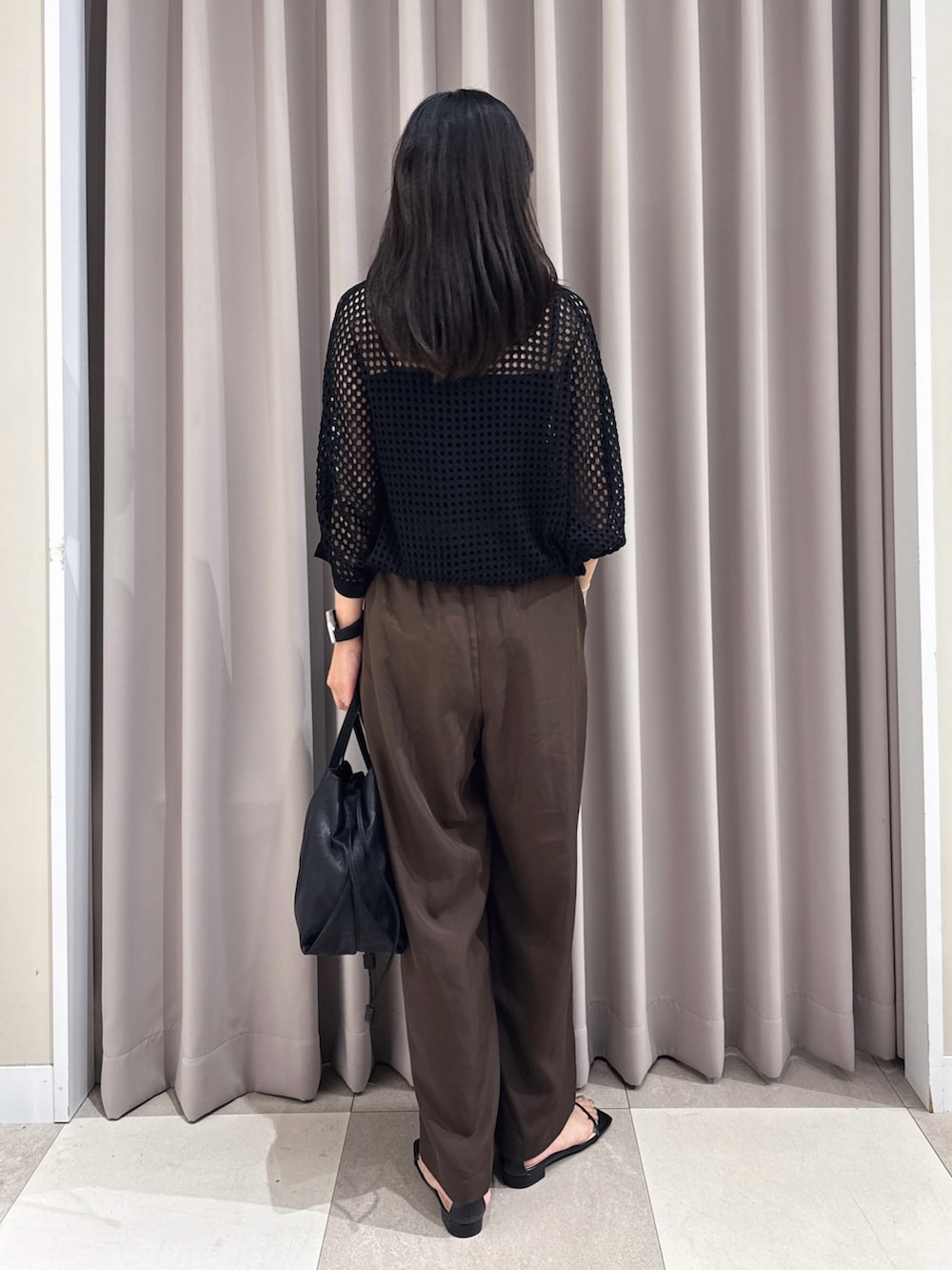 ブラック系のニット/セーター、ブラウン系のその他パンツ、ブラック系のサンダルを着用したレディースの夏コーディネートの3枚目の写真