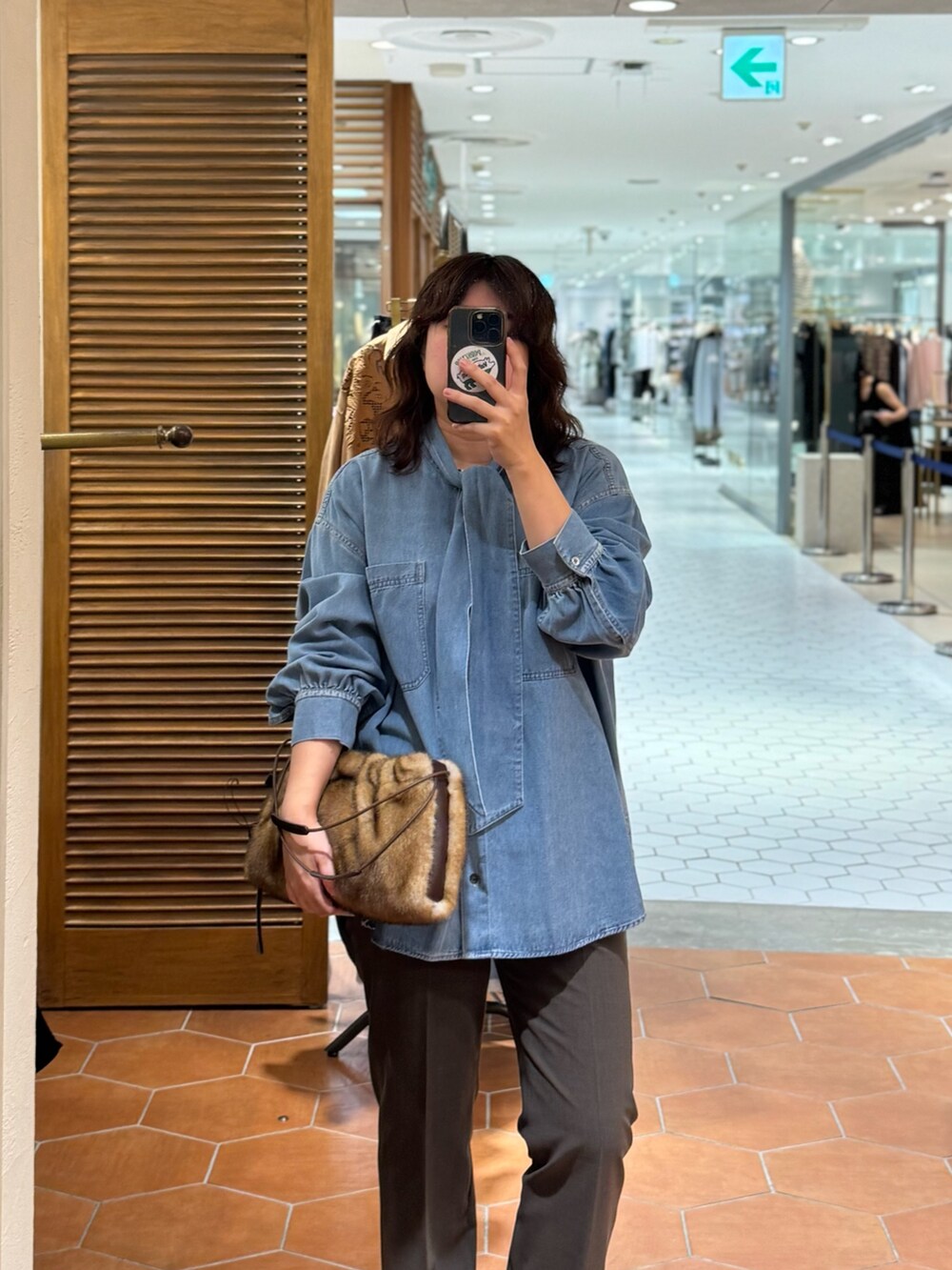 グレー系のその他アウター、ブラウン系のその他パンツ、ブラウン系のボストンバッグを着用したレディースの秋コーディネートの3枚目の写真