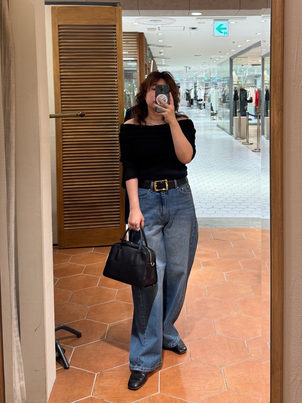ブラック系のボストンバッグ、ブルー系のデニムパンツ、ブラック系のTシャツ/カットソーを着用したレディースの夏コーディネートの2枚目の写真