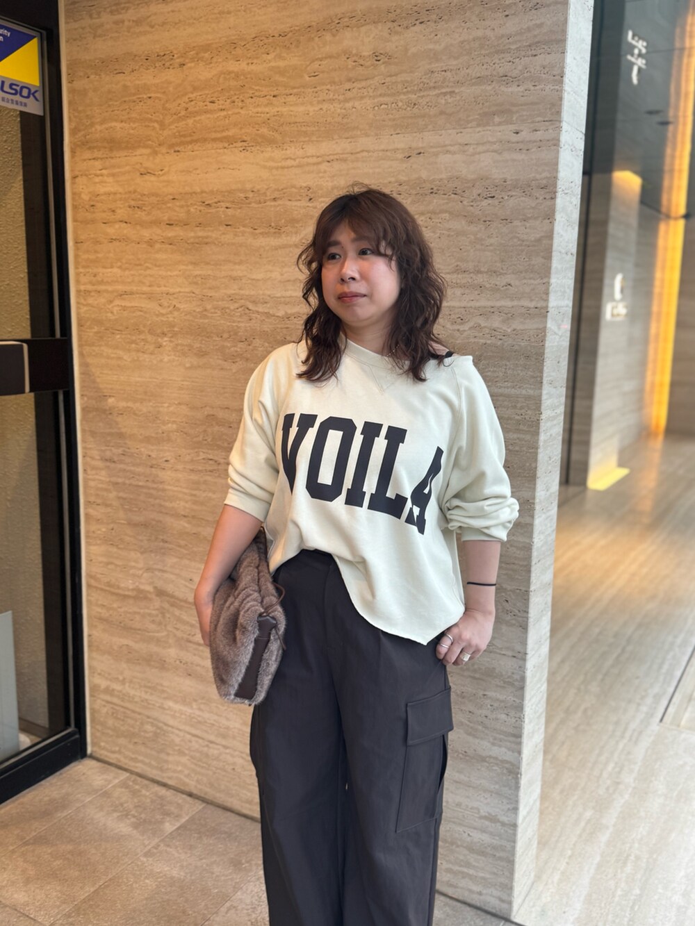 ブラウン系のカーゴパンツ、ブラウン系のハンドバッグ、ベージュ系のパンプスを着用したレディースの夏コーディネートの3枚目の写真