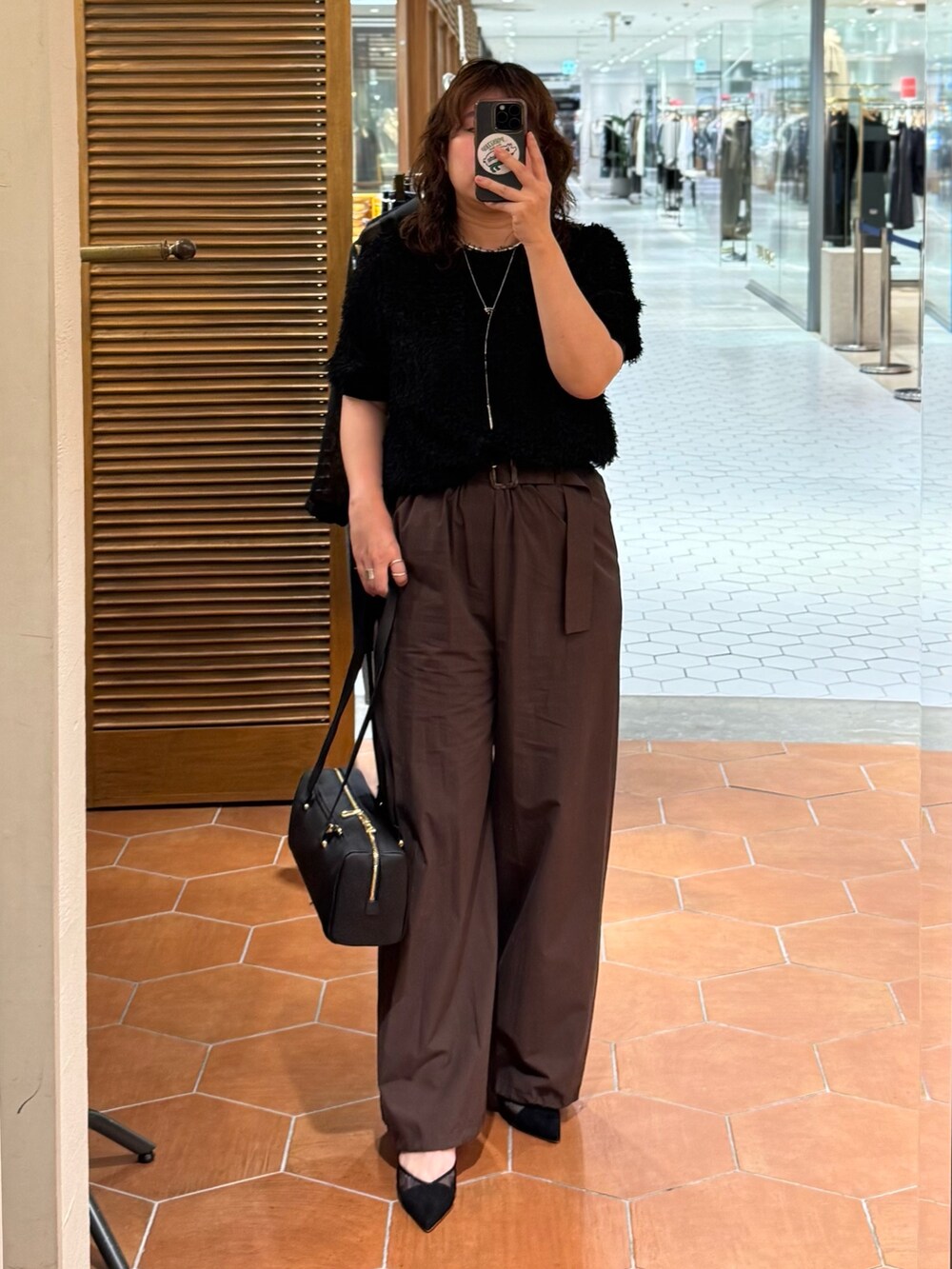 ブラウン系のその他パンツ、ブラック系のショルダーバッグ、ブラック系のシャツ/ブラウスを着用したレディースの夏コーディネートの2枚目の写真