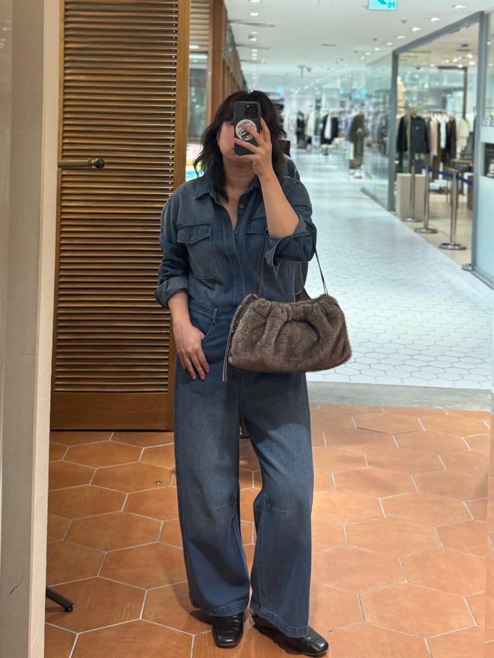 ブラウン系のハンドバッグ、ブルー系のつなぎ/オールインワン、シルバー系のネックレスを着用したレディースの夏コーディネートの2枚目の写真