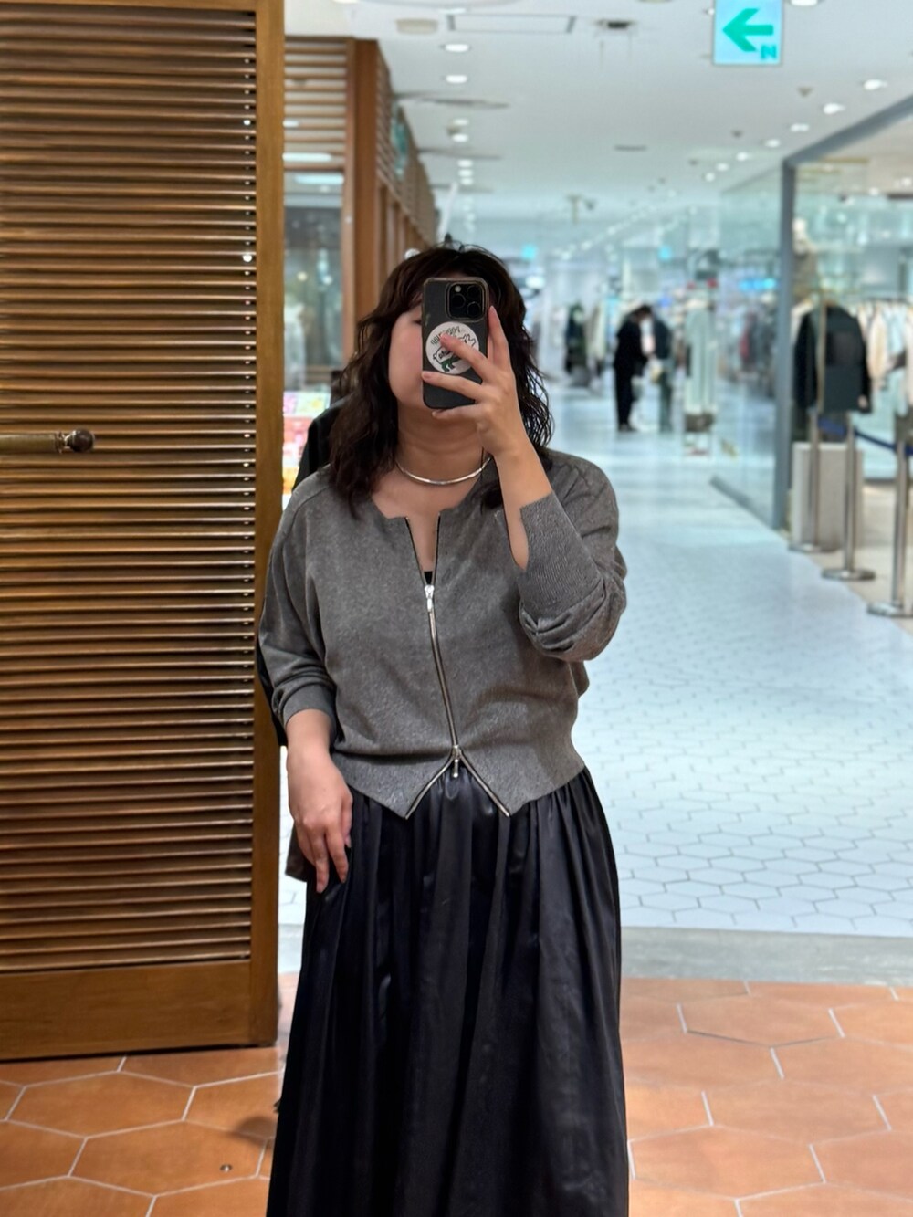 ブラック系のスカート、ブラック系のカーディガン/ボレロ、シルバー系のチョーカーを着用したレディースの秋コーディネートの2枚目の写真