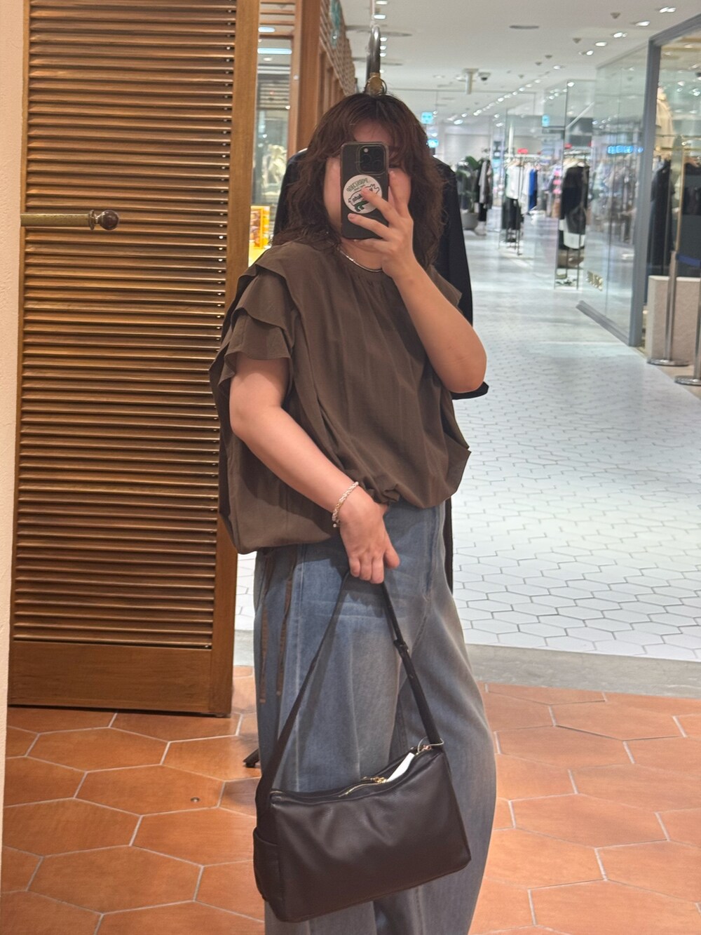 ブラウン系のシャツ/ブラウス、ブラック系のボディバッグ/ウエストポーチ、ブルー系のデニムパンツを着用したレディースの夏コーディネートの3枚目の写真