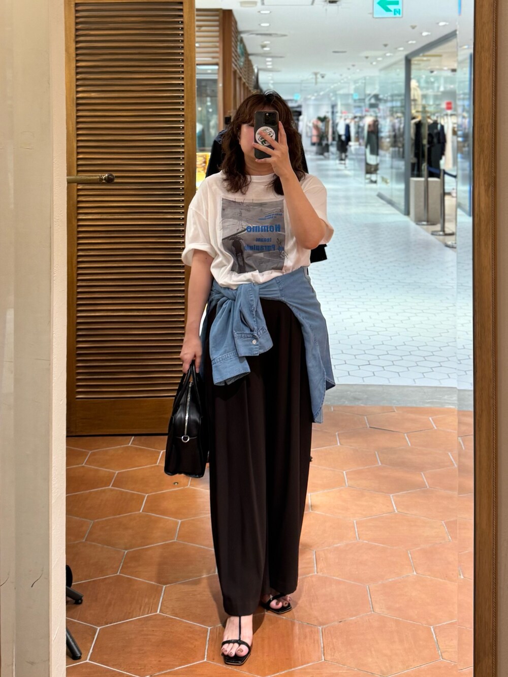 ブラウン系のスラックス、ブルー系のシャツ/ブラウス、ホワイト系のTシャツ/カットソーを着用したレディースの夏コーディネートの2枚目の写真