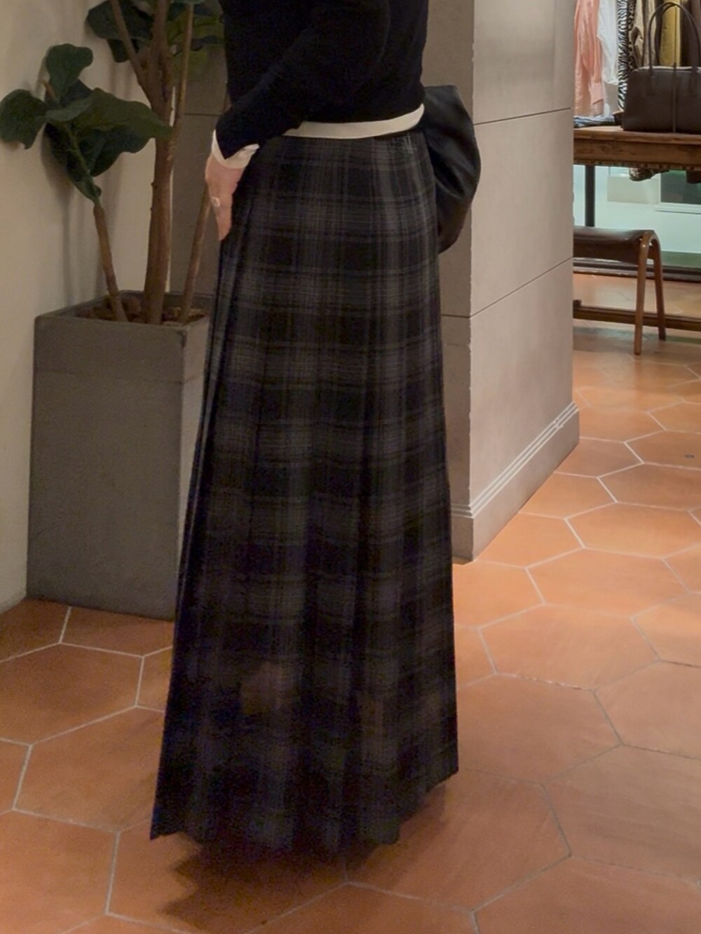 ブラック系のショルダーバッグ、ブラック系のカーディガン/ボレロ、ブラック系のスカートを着用したレディースの夏コーディネートの2枚目の写真