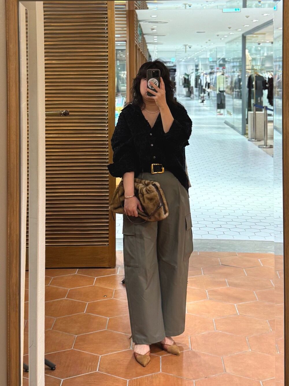 イエロー系のハンドバッグ、ブラウン系のパンプス、ブラック系のシャツ/ブラウスを着用したレディースの夏コーディネートの2枚目の写真