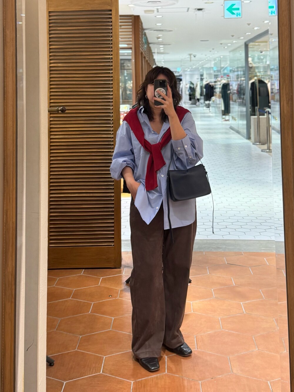 ブラウン系のその他パンツ、ブルー系のショルダーバッグ、レッド系のニット/セーターを着用したレディースの秋コーディネートの2枚目の写真