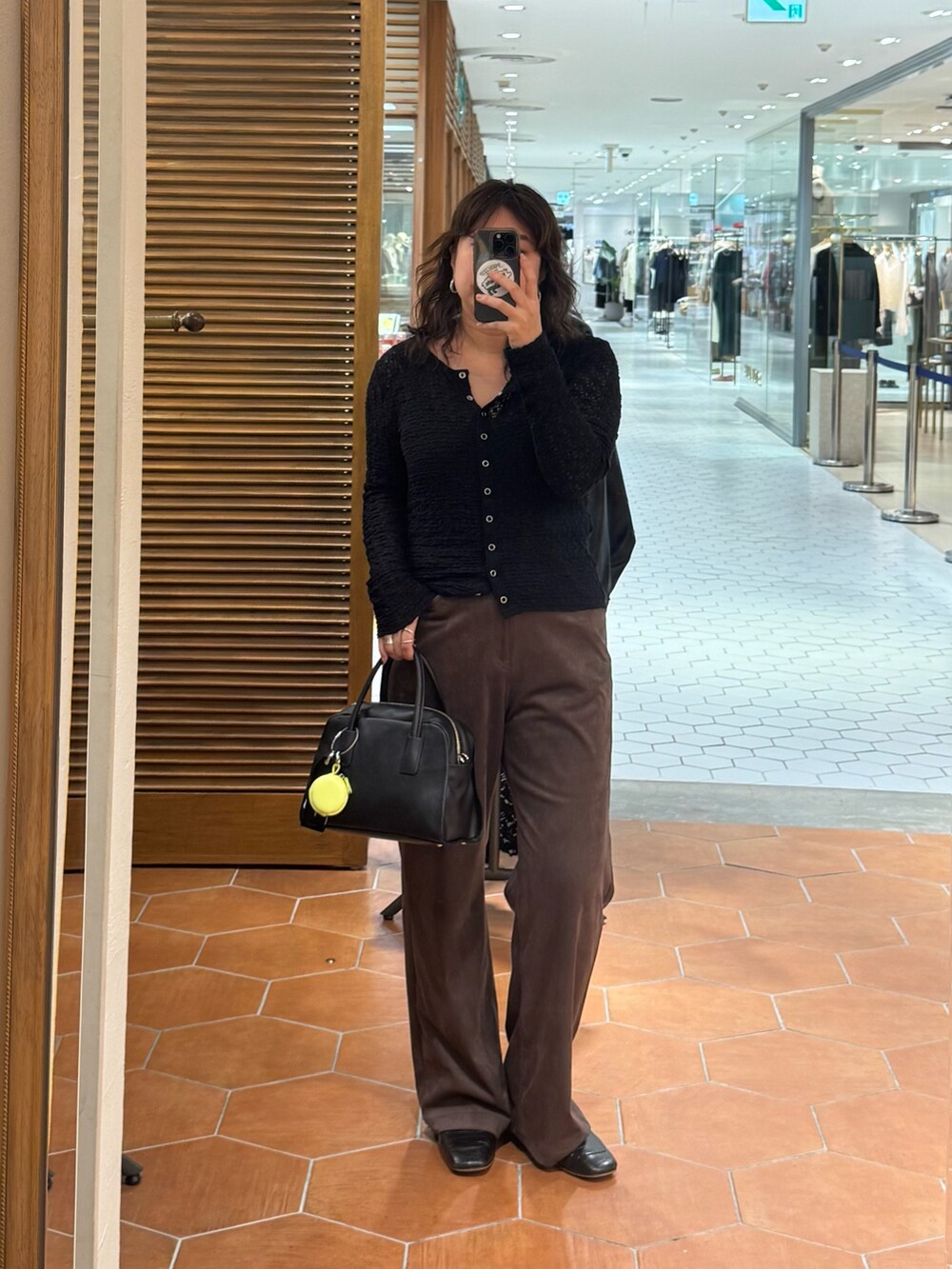 ブラウン系のその他パンツ、ブラック系のボストンバッグ、ブラック系のTシャツ/カットソーを着用したレディースの秋コーディネートの2枚目の写真