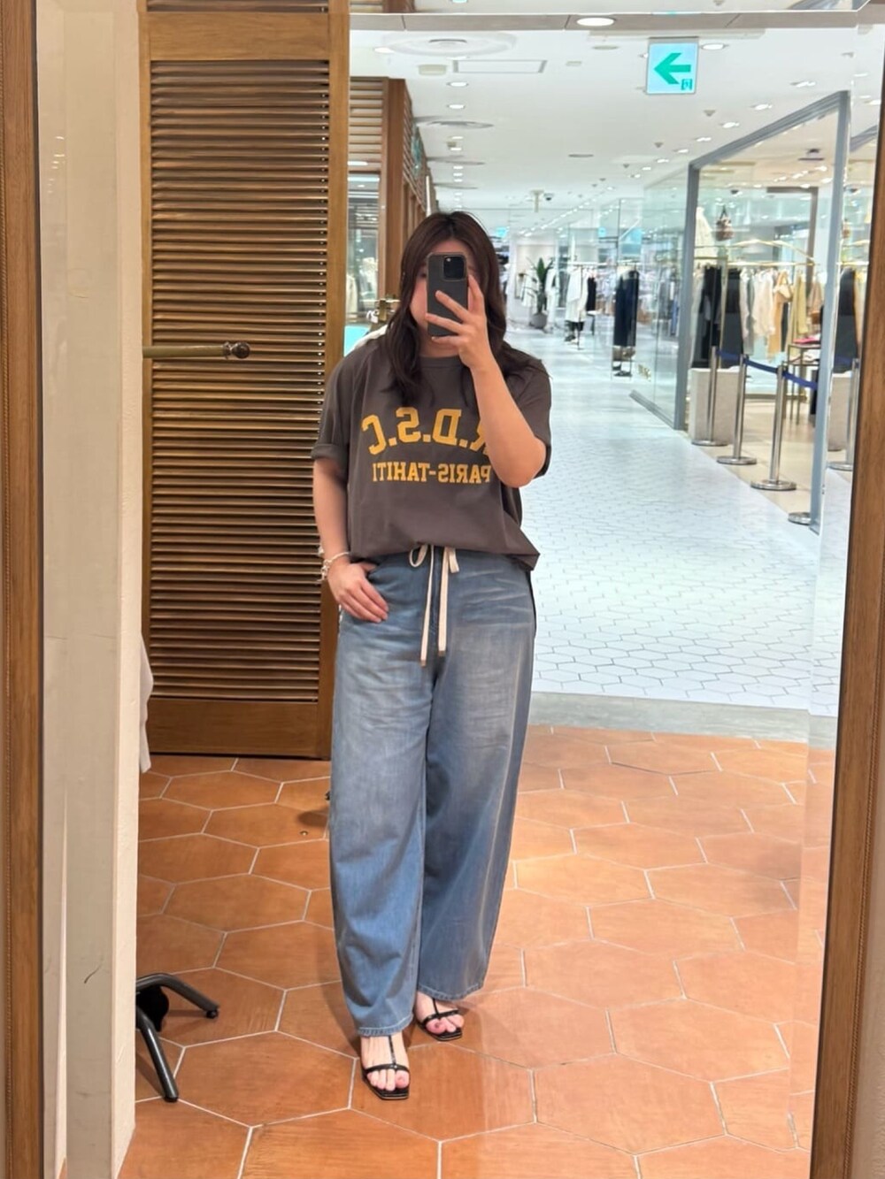 ブルー系のデニムパンツ、ブラック系のブルゾン、ブラウン系のTシャツ/カットソーを着用したレディースの夏コーディネートの2枚目の写真