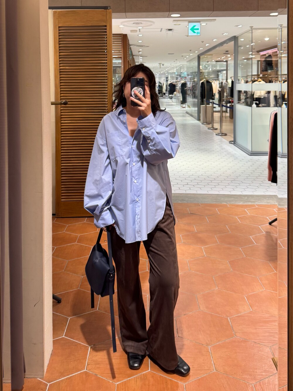 ブルー系のショルダーバッグ、ブラウン系のその他パンツ、ブルー系のシャツ/ブラウスを着用したレディースの秋コーディネートの2枚目の写真