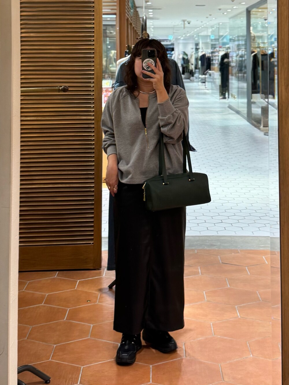 ブラック系のスカート、ブラック系のショルダーバッグ、ブラック系のシャツ/ブラウスを着用したレディースの秋コーディネートの3枚目の写真