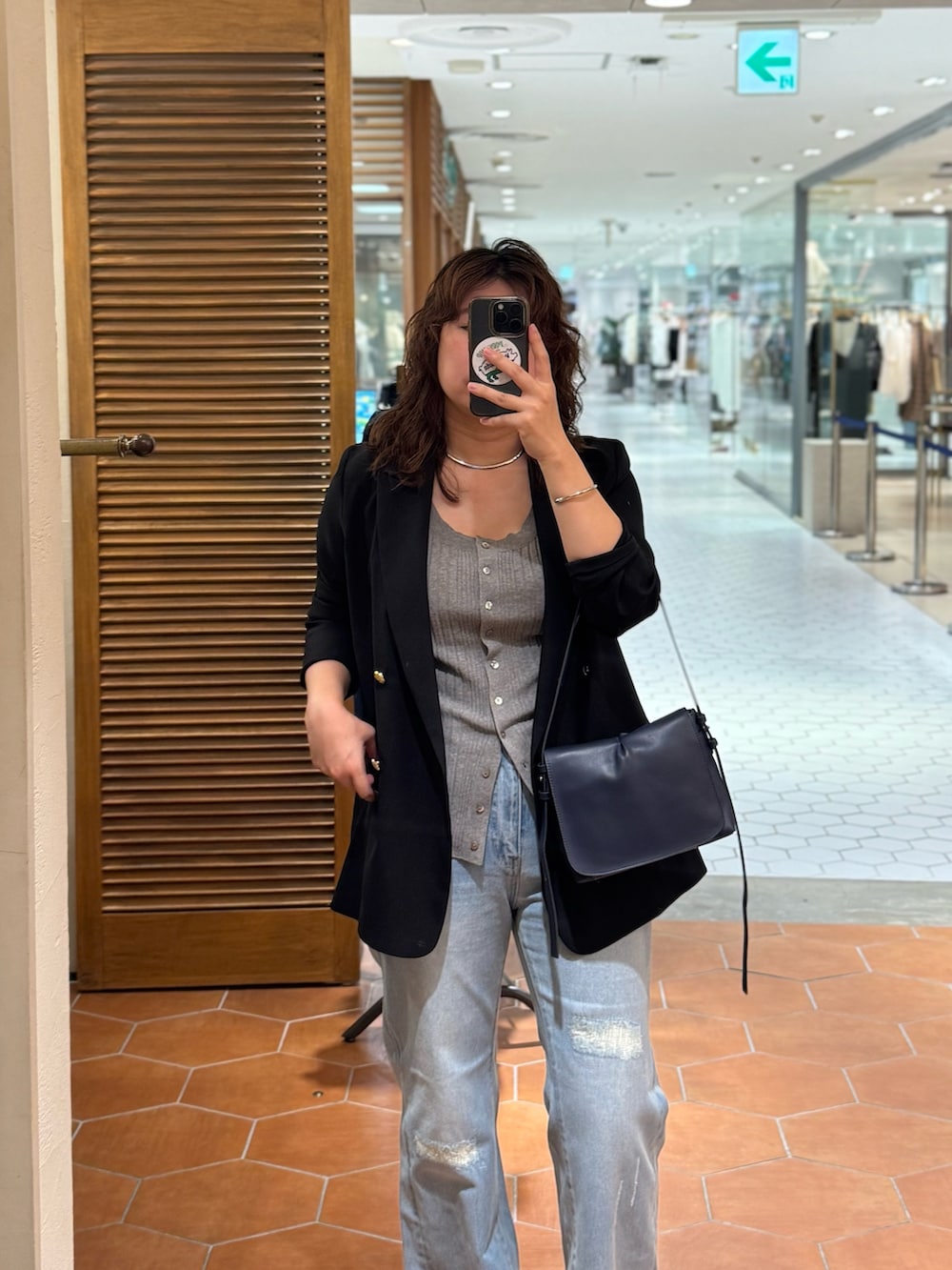 ブルー系のショルダーバッグ、ブルー系のデニムパンツ、ブルー系のテーラードジャケットを着用したレディースの夏コーディネートの3枚目の写真