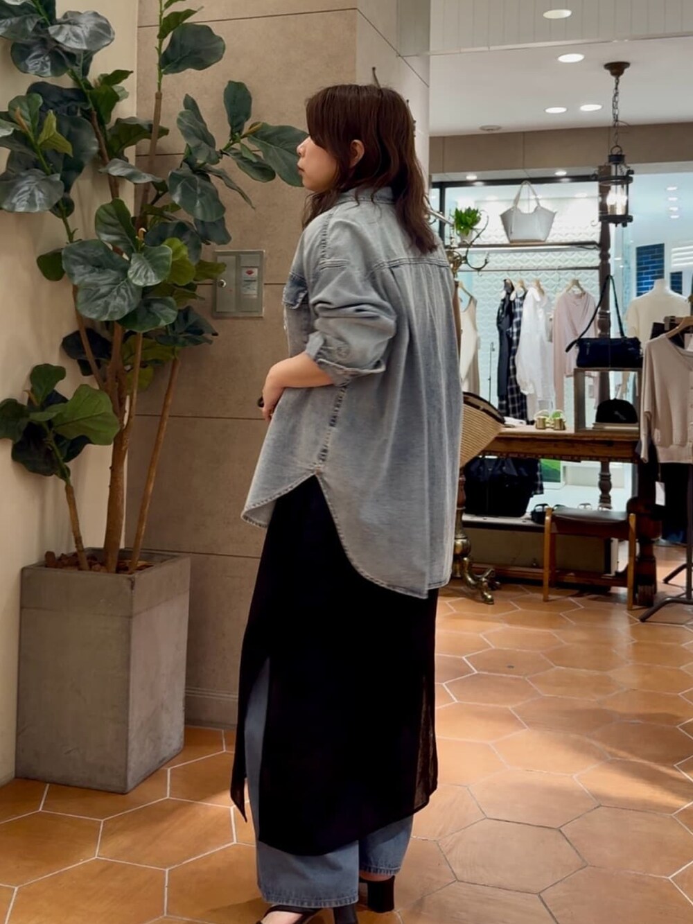 ブルー系のシャツ/ブラウス、ブラック系のワンピース、ブルー系のデニムパンツを着用したレディースの夏コーディネートの2枚目の写真
