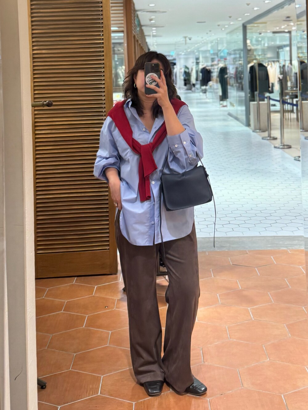 ブルー系のショルダーバッグ、ブラウン系のその他パンツ、ブルー系のシャツ/ブラウスを着用したレディースの秋コーディネートの3枚目の写真