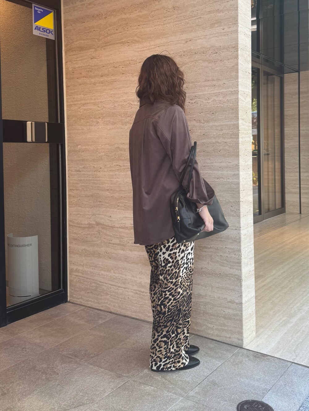 ベージュ系のその他パンツ、ブラック系のローファー、ブラック系のボストンバッグを着用したレディースの夏コーディネートの2枚目の写真