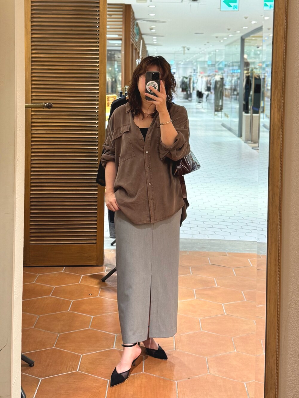 ブラウン系のシャツ/ブラウス、ブラック系のスカート、ブラック系のパンプスを着用したレディースの夏コーディネートの2枚目の写真