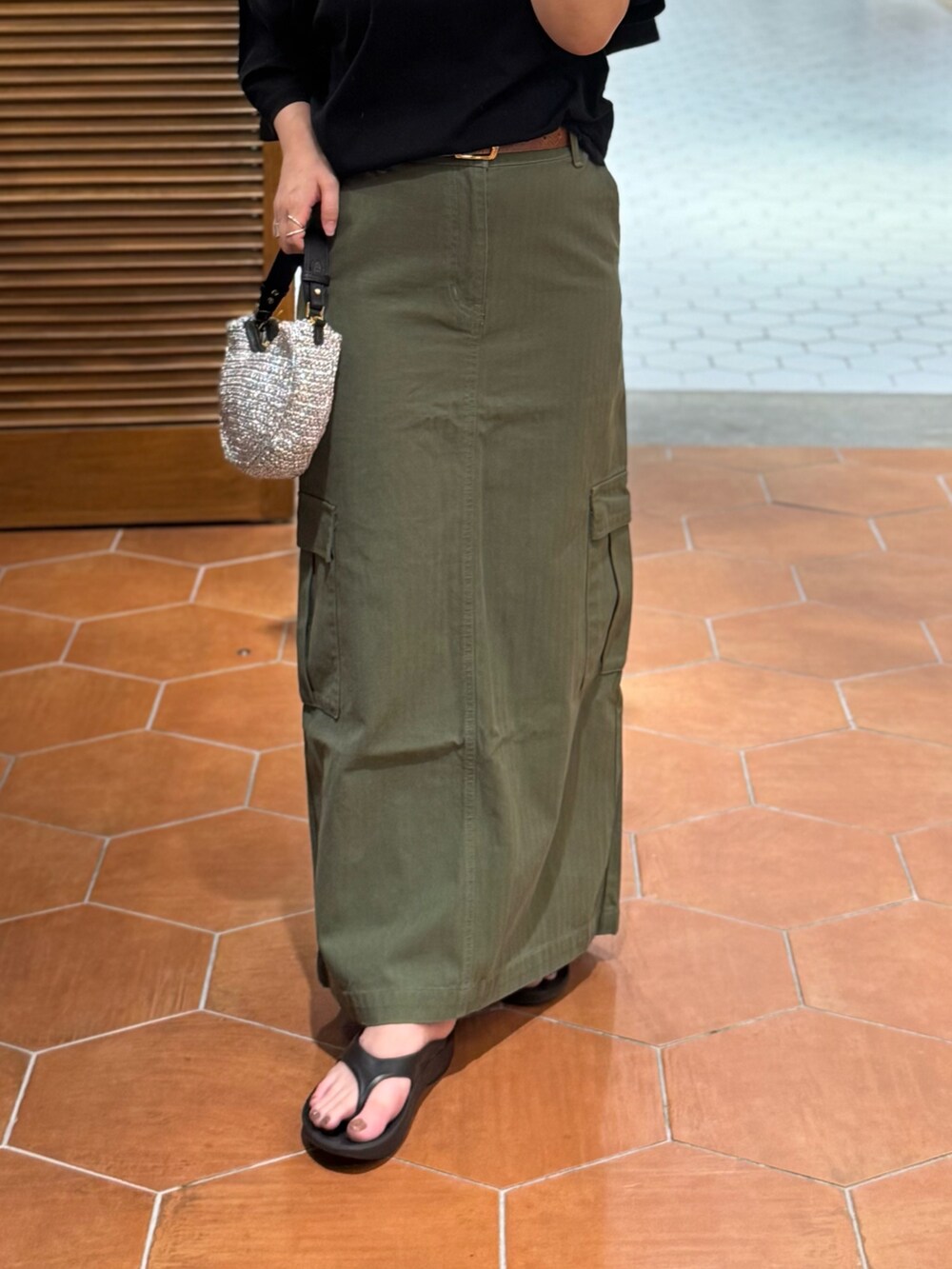 グリーン系のスカート、ブラック系のTシャツ/カットソー、イエロー系のベルトを着用したレディースの夏コーディネートの3枚目の写真