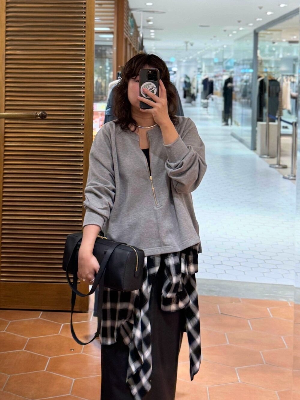 ブラック系のスカート、ブラック系のショルダーバッグ、ブラック系のシャツ/ブラウスを着用したレディースの秋コーディネートの2枚目の写真