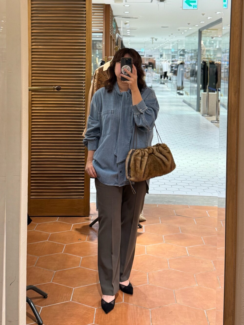 グレー系のその他アウター、ブラウン系のその他パンツ、ブラウン系のボストンバッグを着用したレディースの秋コーディネートの2枚目の写真