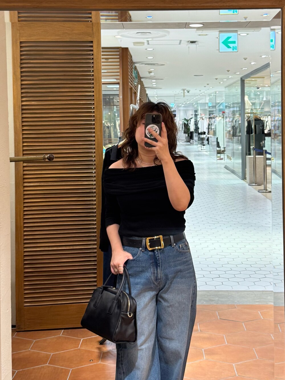 ブラック系のボストンバッグ、ブルー系のデニムパンツ、ブラック系のTシャツ/カットソーを着用したレディースの夏コーディネートの3枚目の写真