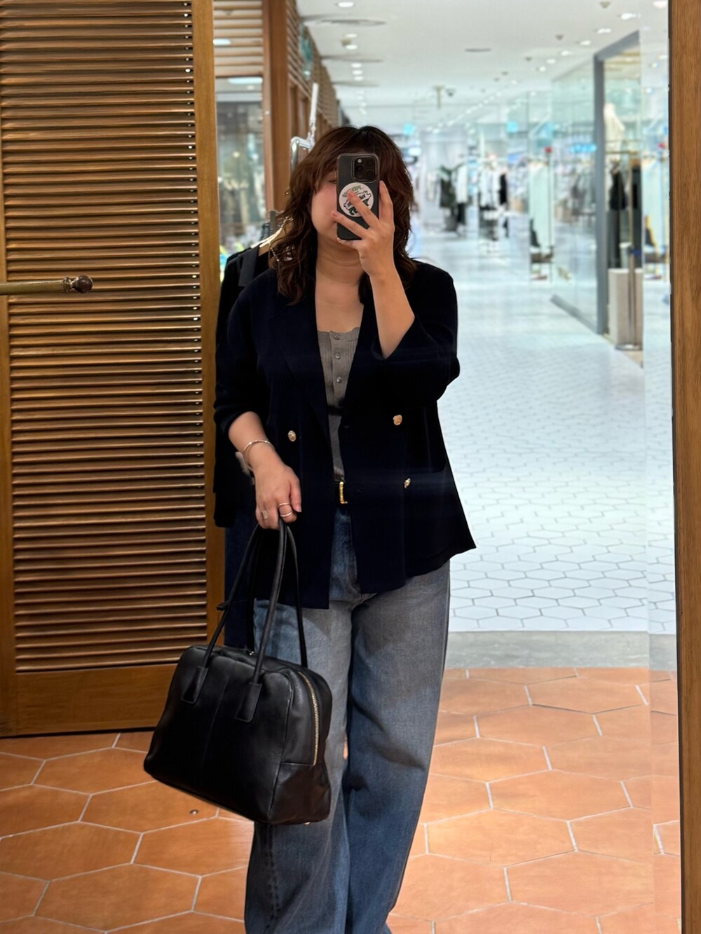 ベージュ系のその他シューズ、ブルー系のデニムパンツ、ブラック系のボストンバッグを着用したレディースの夏コーディネートの2枚目の写真