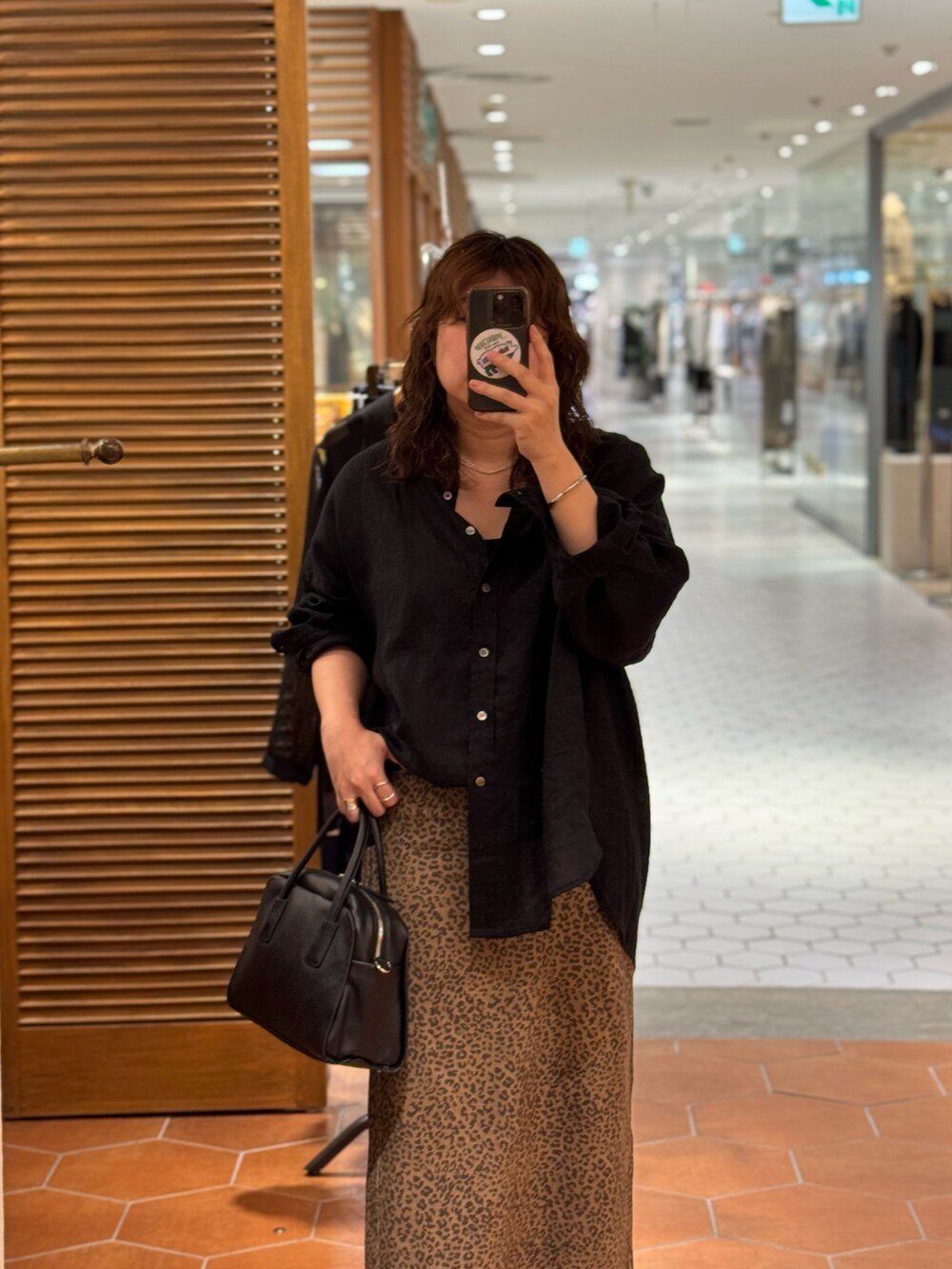 ブラウン系のスカート、ブラック系のシャツ/ブラウス、ブラック系のパンプスを着用したレディースの夏コーディネートの3枚目の写真