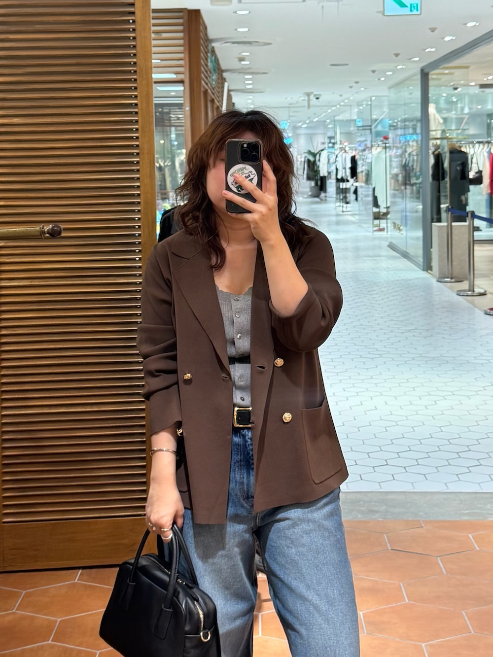 ブルー系のデニムパンツ、ベージュ系のその他シューズ、ブラック系のボストンバッグを着用したレディースの夏コーディネートの2枚目の写真