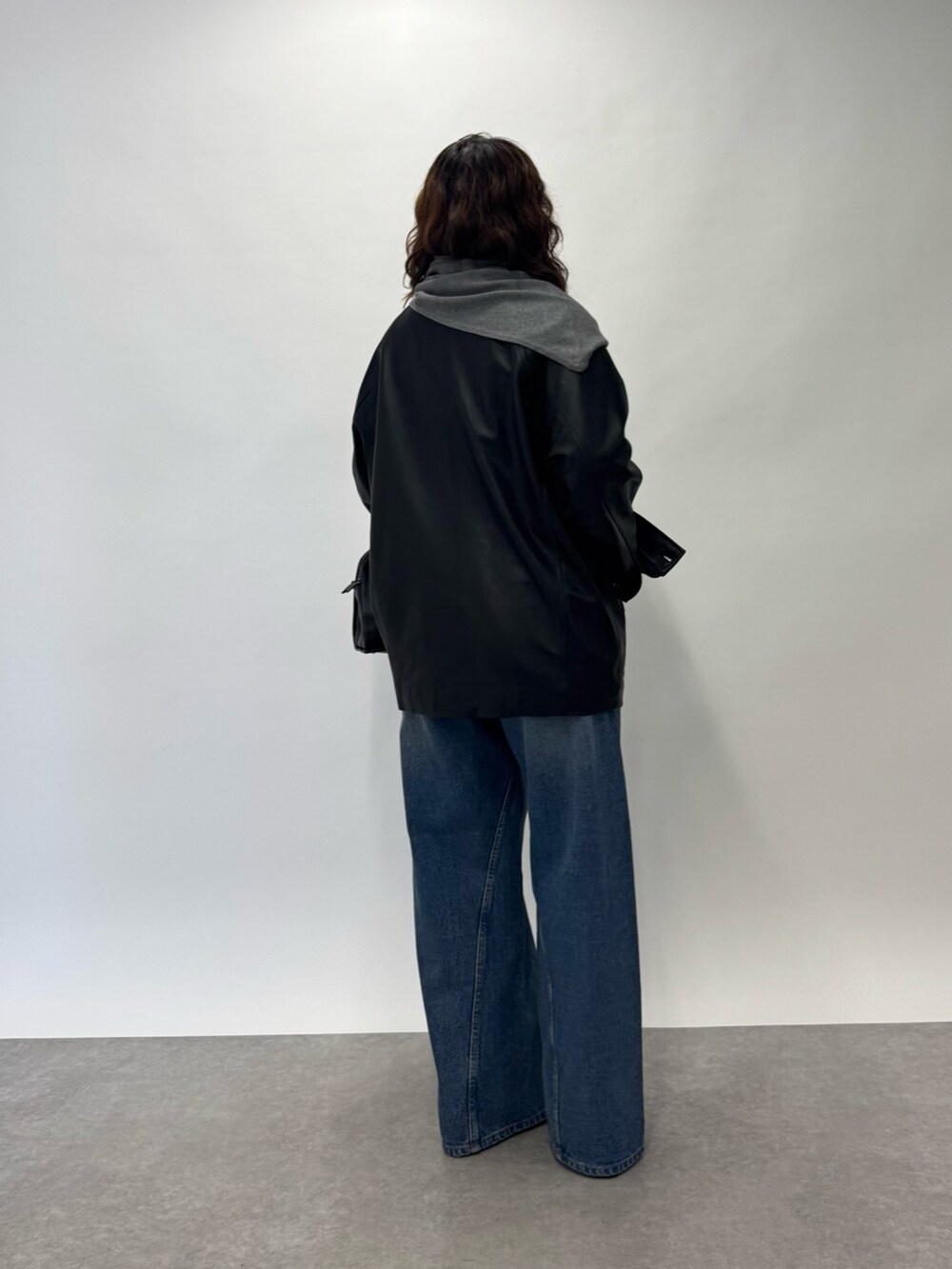 ブルー系のデニムパンツ、グリーン系のニット/セーター、ブラック系のボストンバッグを着用したレディースの夏コーディネートの2枚目の写真