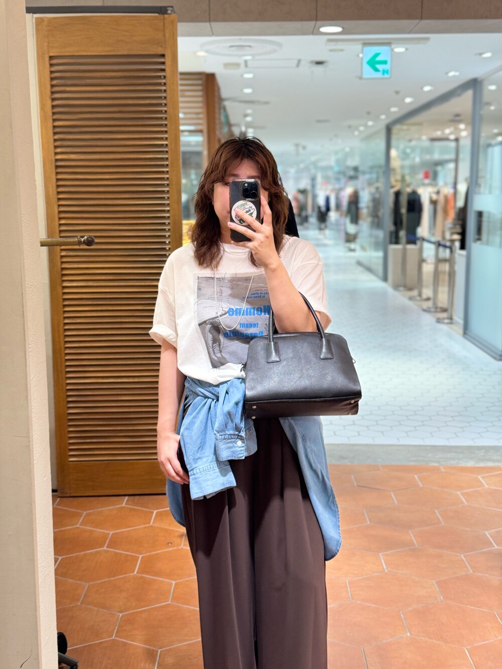 ブラウン系のスラックス、ブルー系のシャツ/ブラウス、ホワイト系のTシャツ/カットソーを着用したレディースの夏コーディネートの3枚目の写真