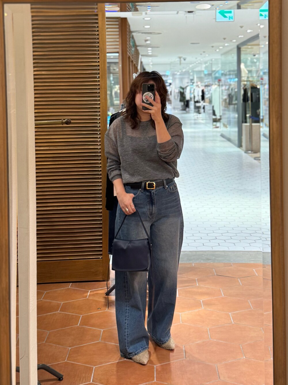 ブルー系のデニムパンツ、ベージュ系のその他シューズ、ブルー系のショルダーバッグを着用したレディースの夏コーディネートの3枚目の写真