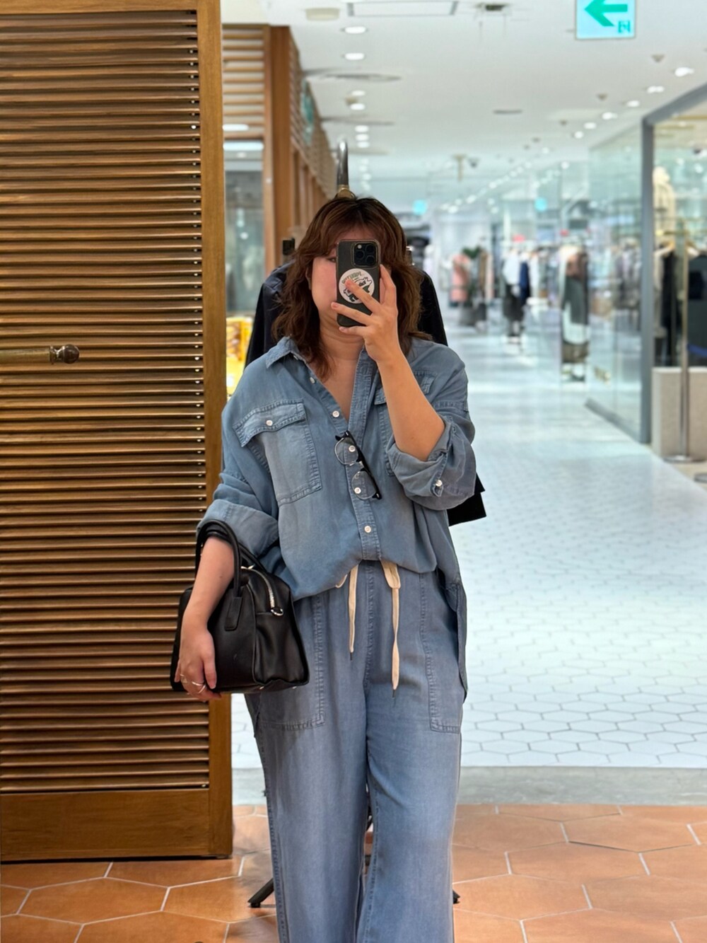 ブルー系のその他パンツ、ブルー系のシャツ/ブラウス、ブラック系のボストンバッグを着用したレディースの夏コーディネートの2枚目の写真