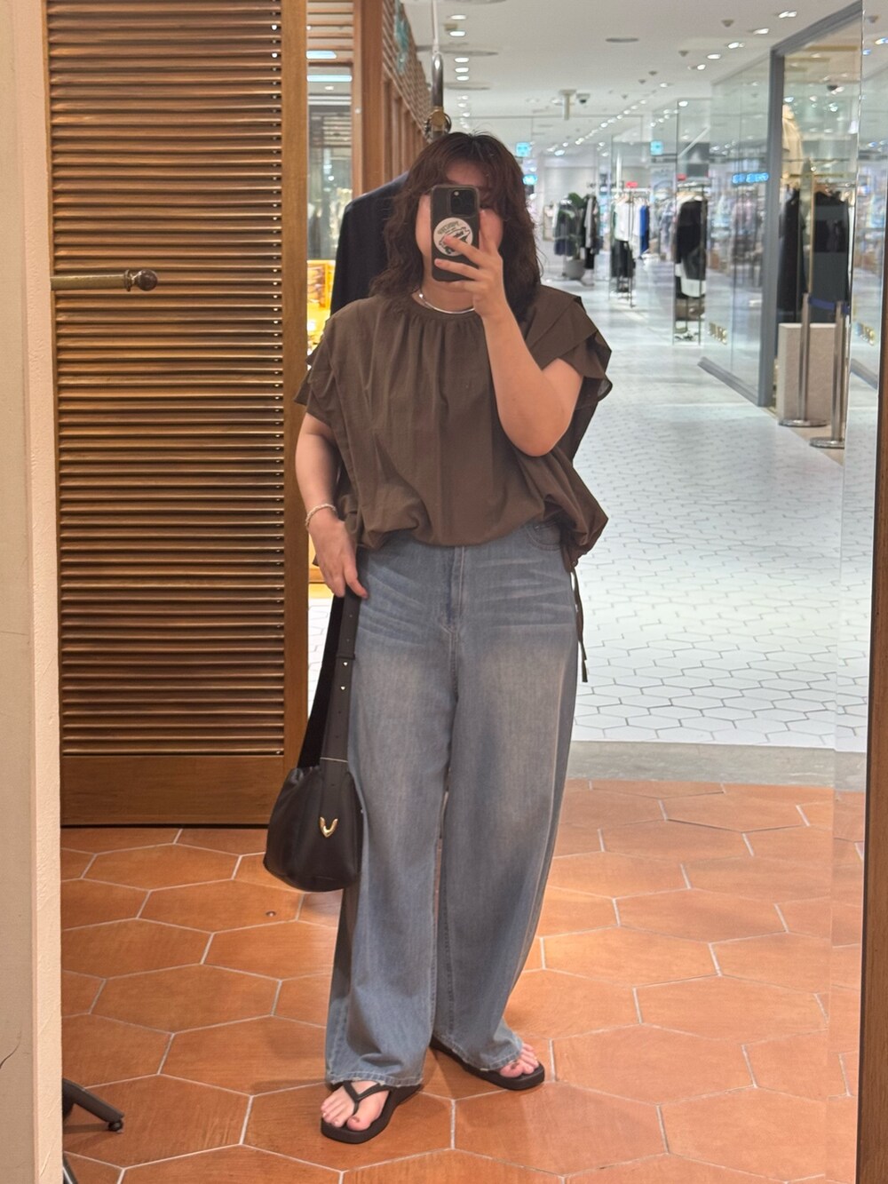 ブラウン系のシャツ/ブラウス、ブラック系のボディバッグ/ウエストポーチ、ブルー系のデニムパンツを着用したレディースの夏コーディネートの2枚目の写真