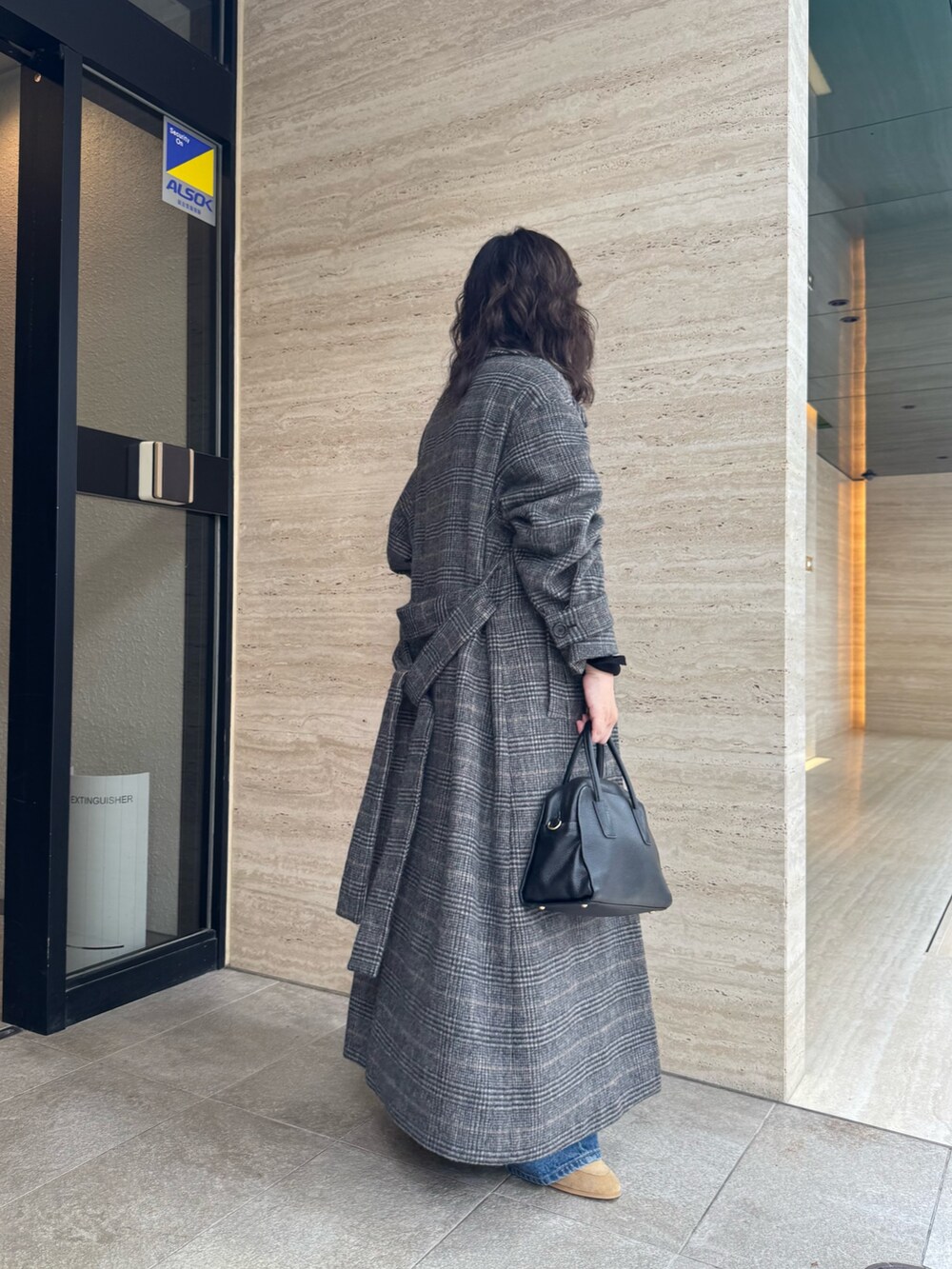 ベージュ系のローファー、ブルー系のデニムパンツ、ブラック系のボストンバッグを着用したレディースの秋コーディネートの2枚目の写真