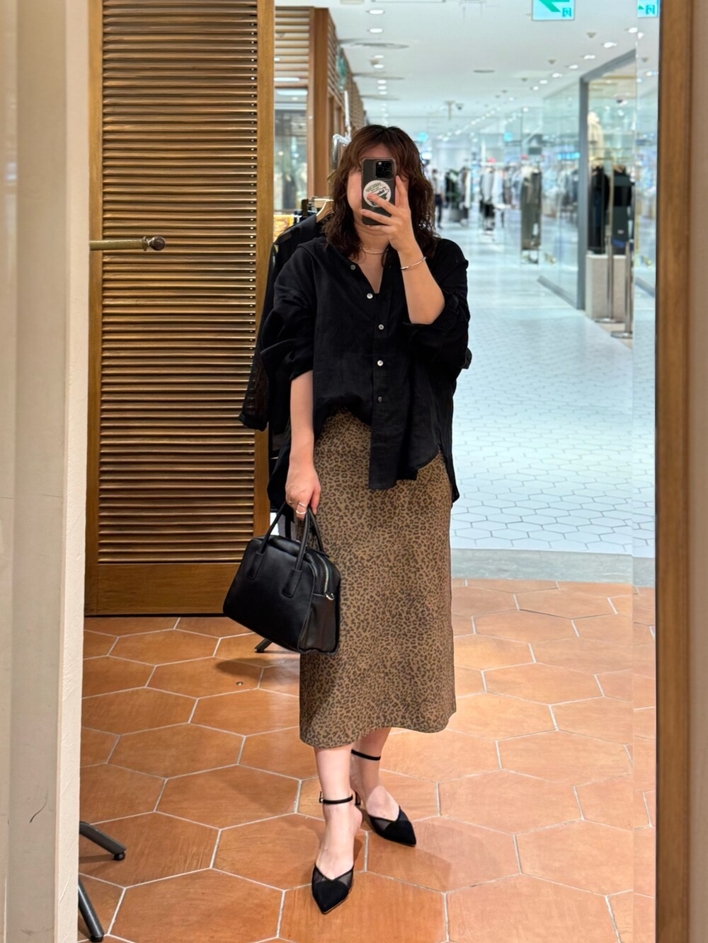ブラウン系のスカート、ブラック系のシャツ/ブラウス、ブラック系のパンプスを着用したレディースの夏コーディネートの2枚目の写真