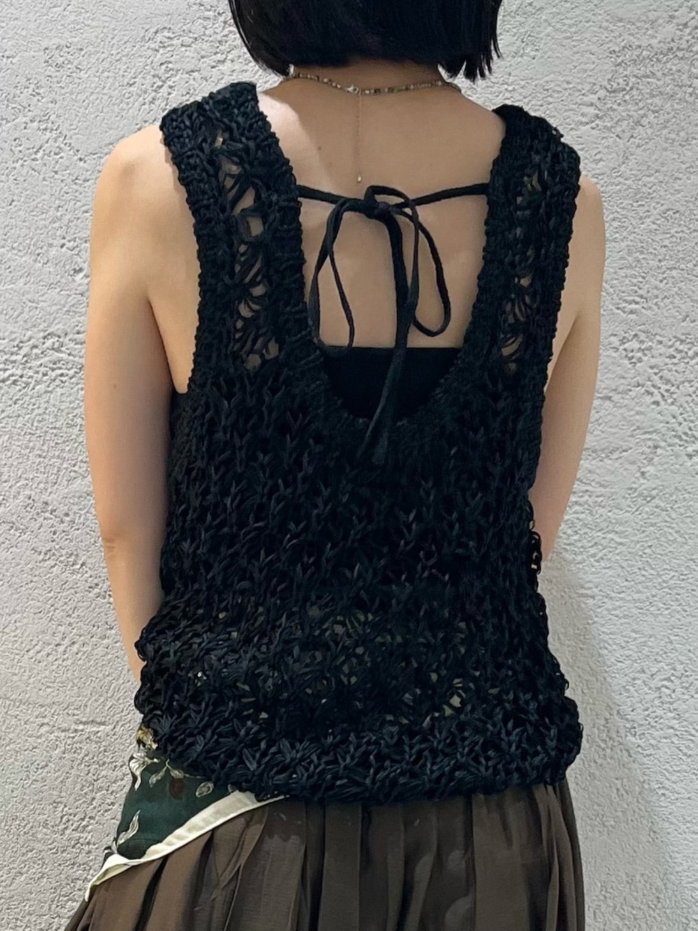 ブラック系のニット/セーター、ブラック系のサンダル、ブラック系のハンドバッグを着用したレディースの夏コーディネートの5枚目の写真