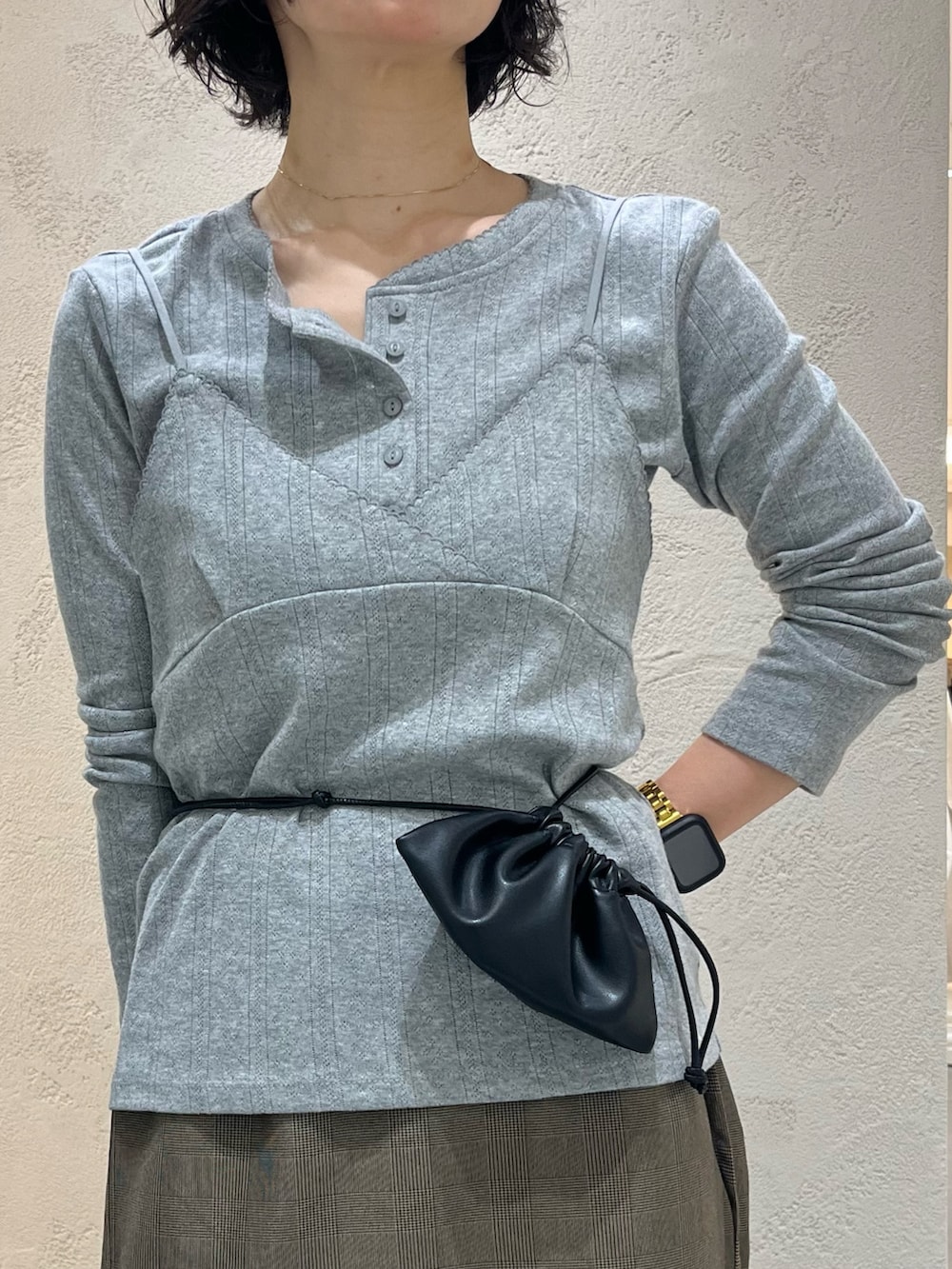 グレー系のTシャツ/カットソー、ベージュ系のスカート、ブラック系のポーチを着用したレディースの秋コーディネートの5枚目の写真