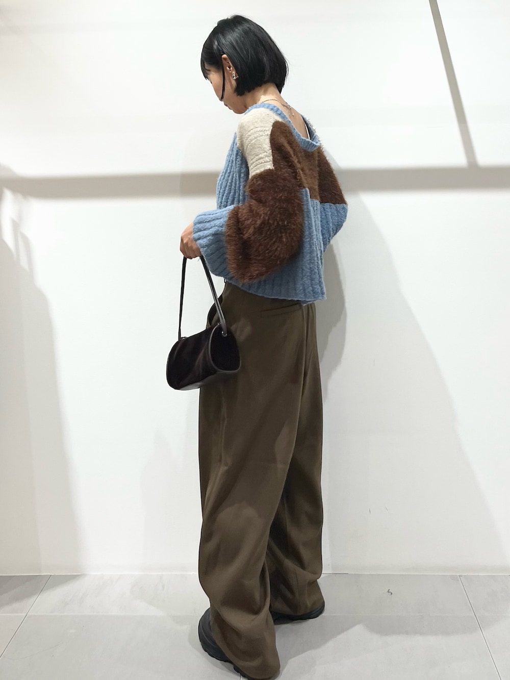 ブラウン系のその他パンツ、ブラック系のブーツ、ブラウン系のショルダーバッグを着用したレディースの秋コーディネートの2枚目の写真