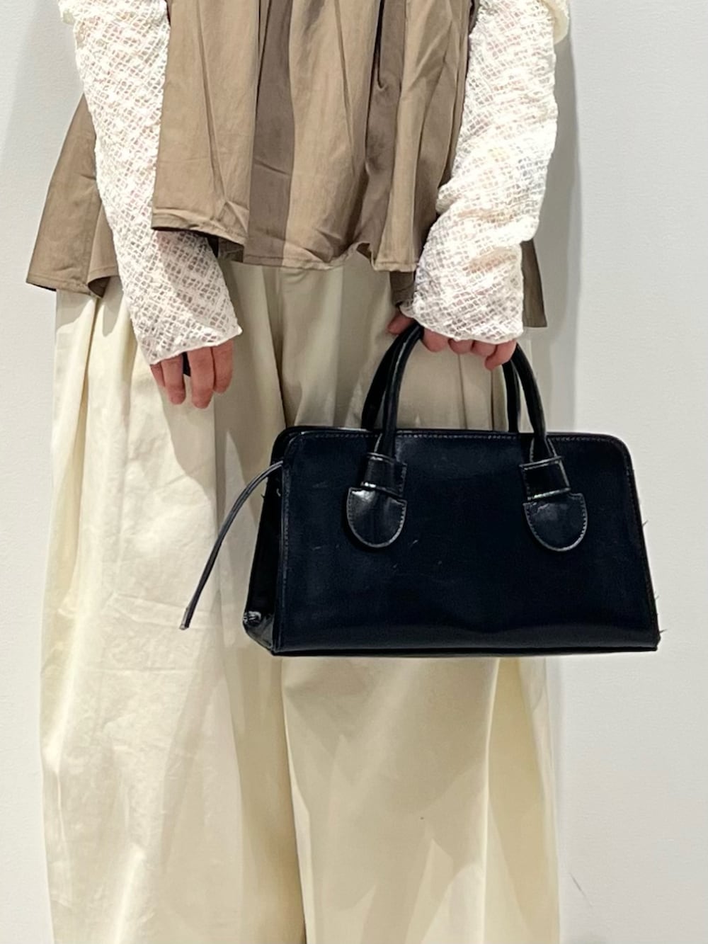 グリーン系のその他トップス、ブラック系のその他シューズ、ホワイト系のその他パンツを着用したレディースの春コーディネートの4枚目の写真