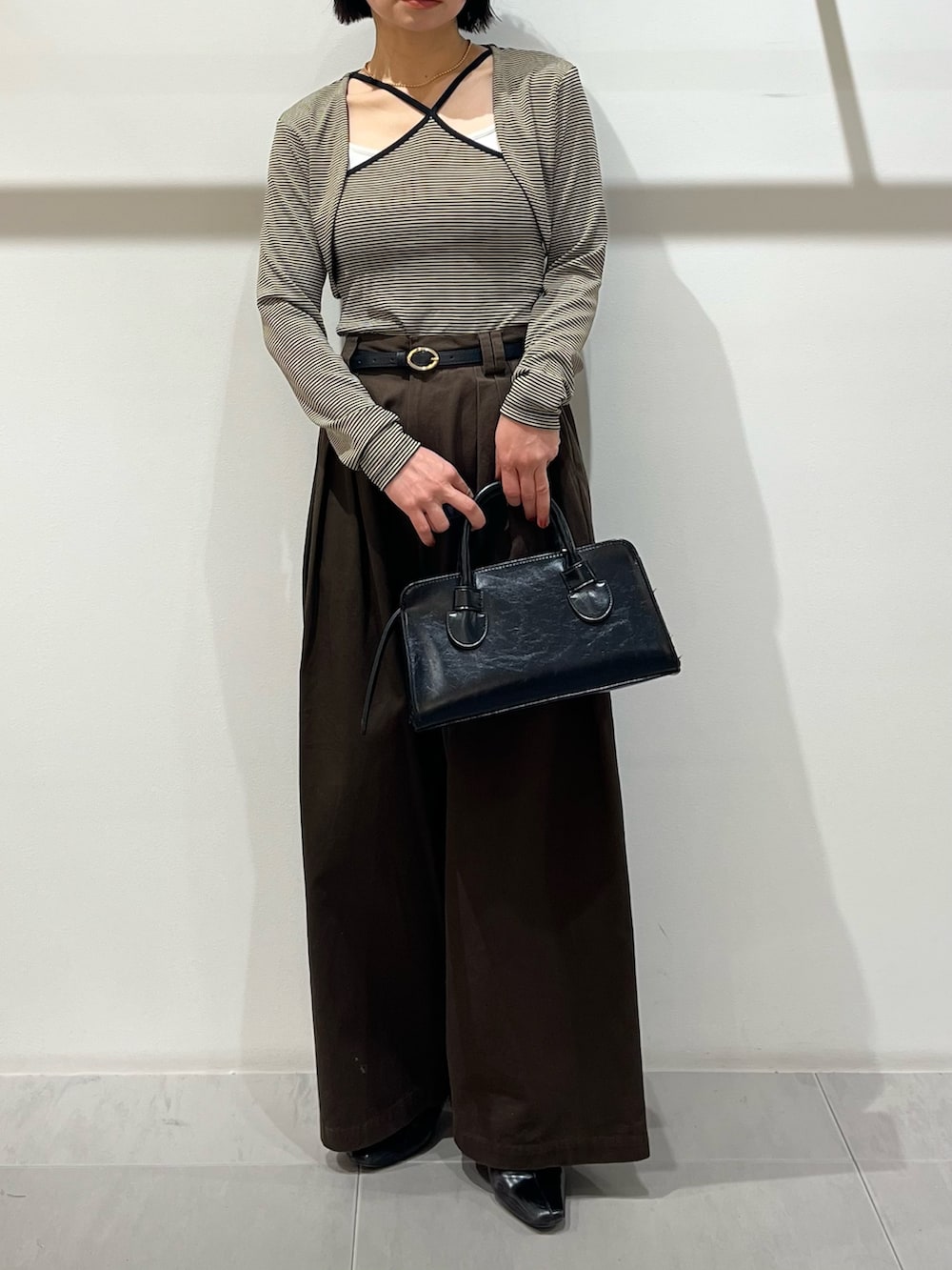 ベージュ系のキャミソール、ブラウン系のその他パンツ、ブラック系のボストンバッグを着用したレディースの春コーディネートの5枚目の写真