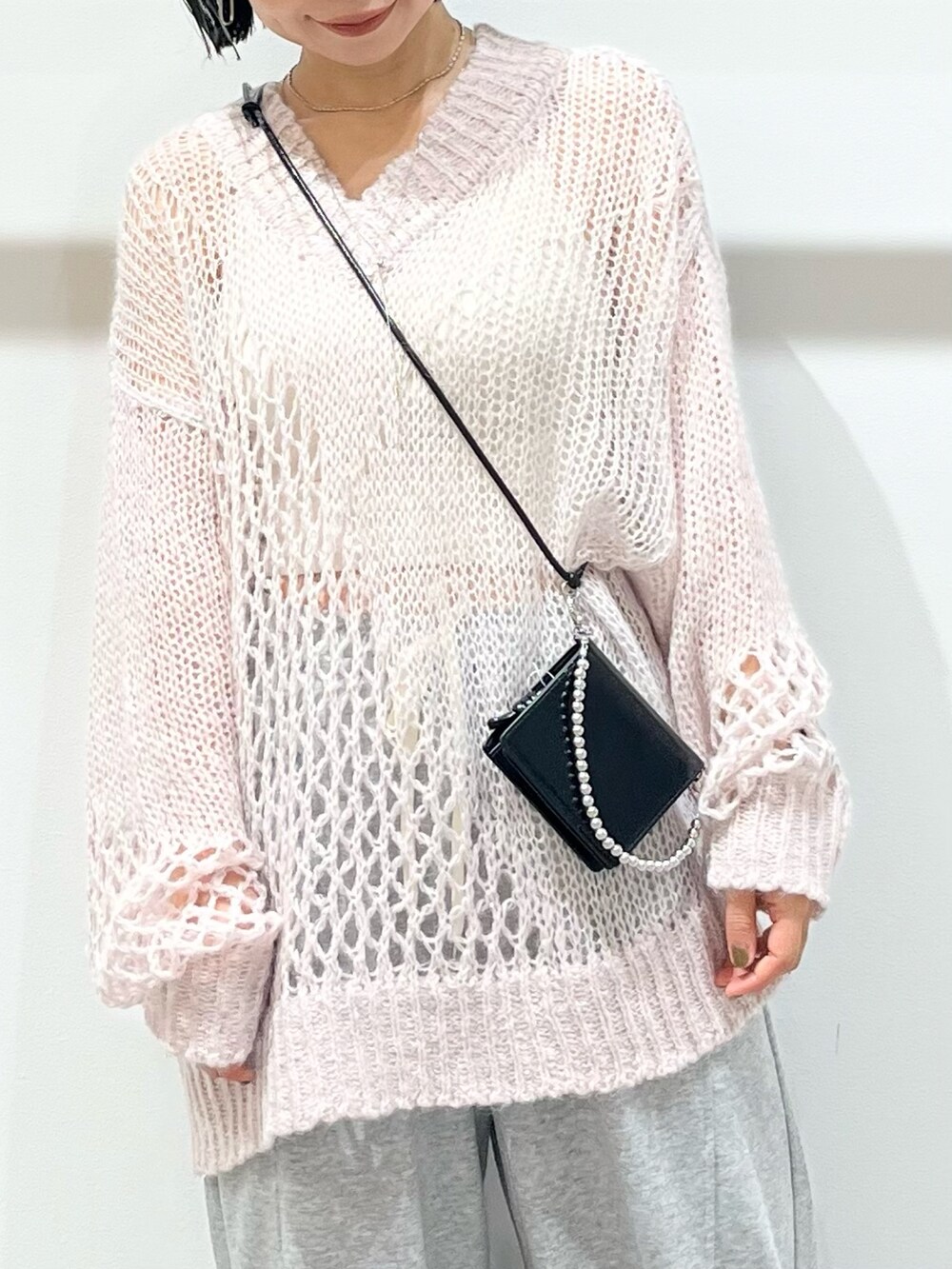 ピンク系のニット/セーター、グレー系のその他パンツ、ブラック系のその他シューズを着用したレディースの秋コーディネートの4枚目の写真